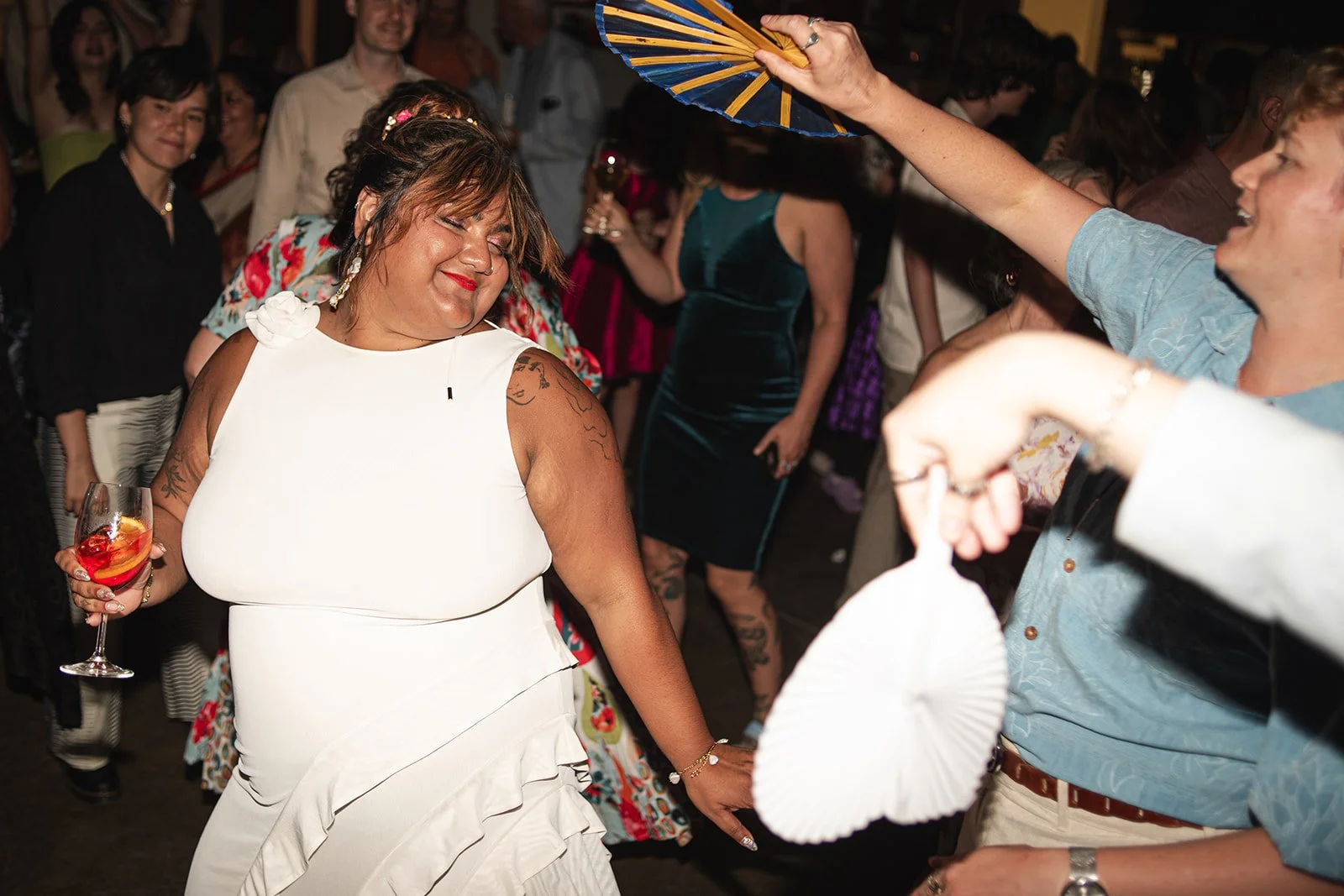 Candid Photo of Bride Being Fanned By Her Wedding Guests