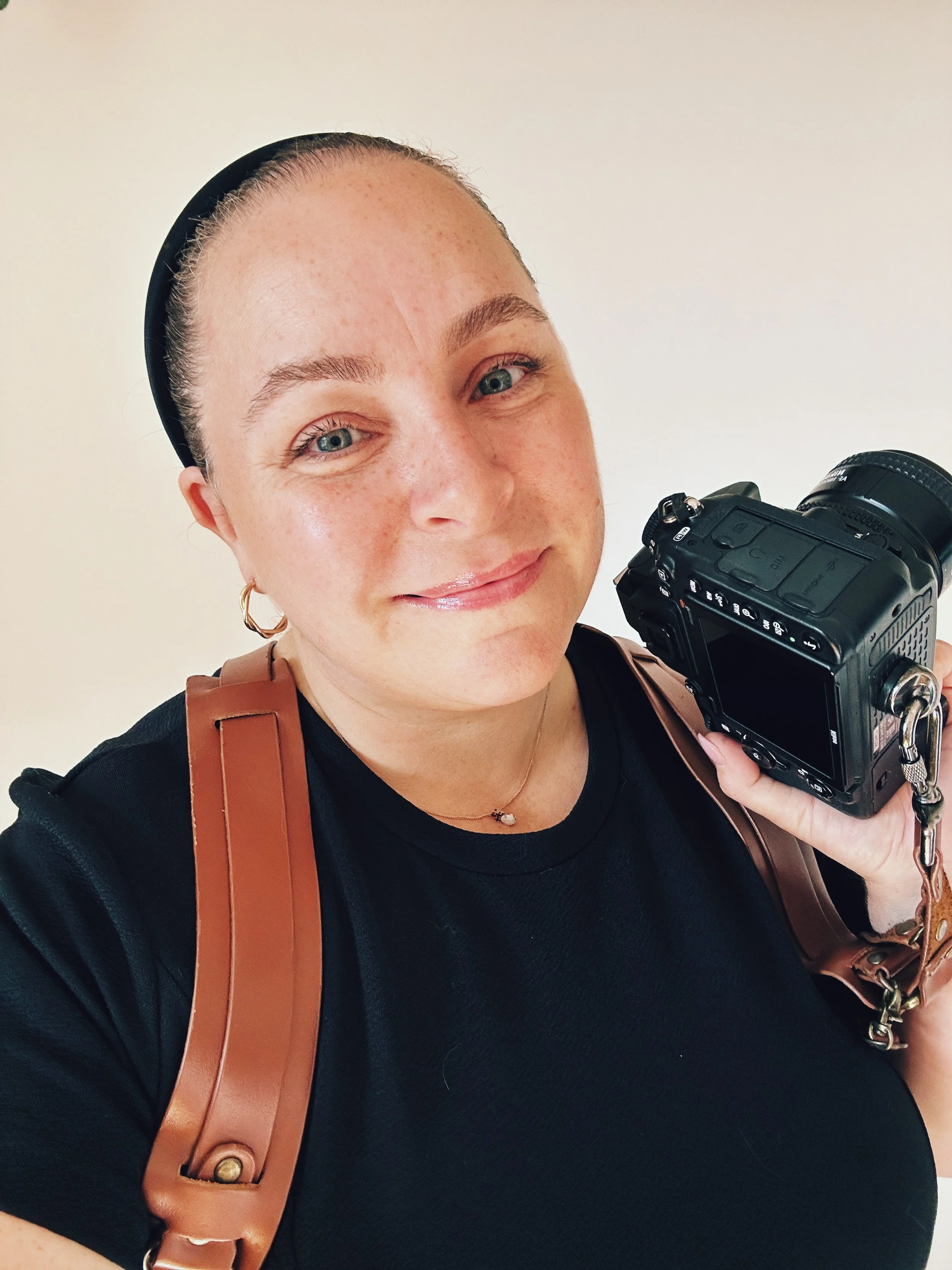 Jessica Laforet holding a camera and wearing a black shirt.
