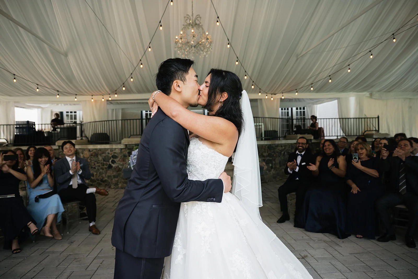A bride and groom sharing their first kiss at their intimate wedding ceremony at The Guild Inn Estate