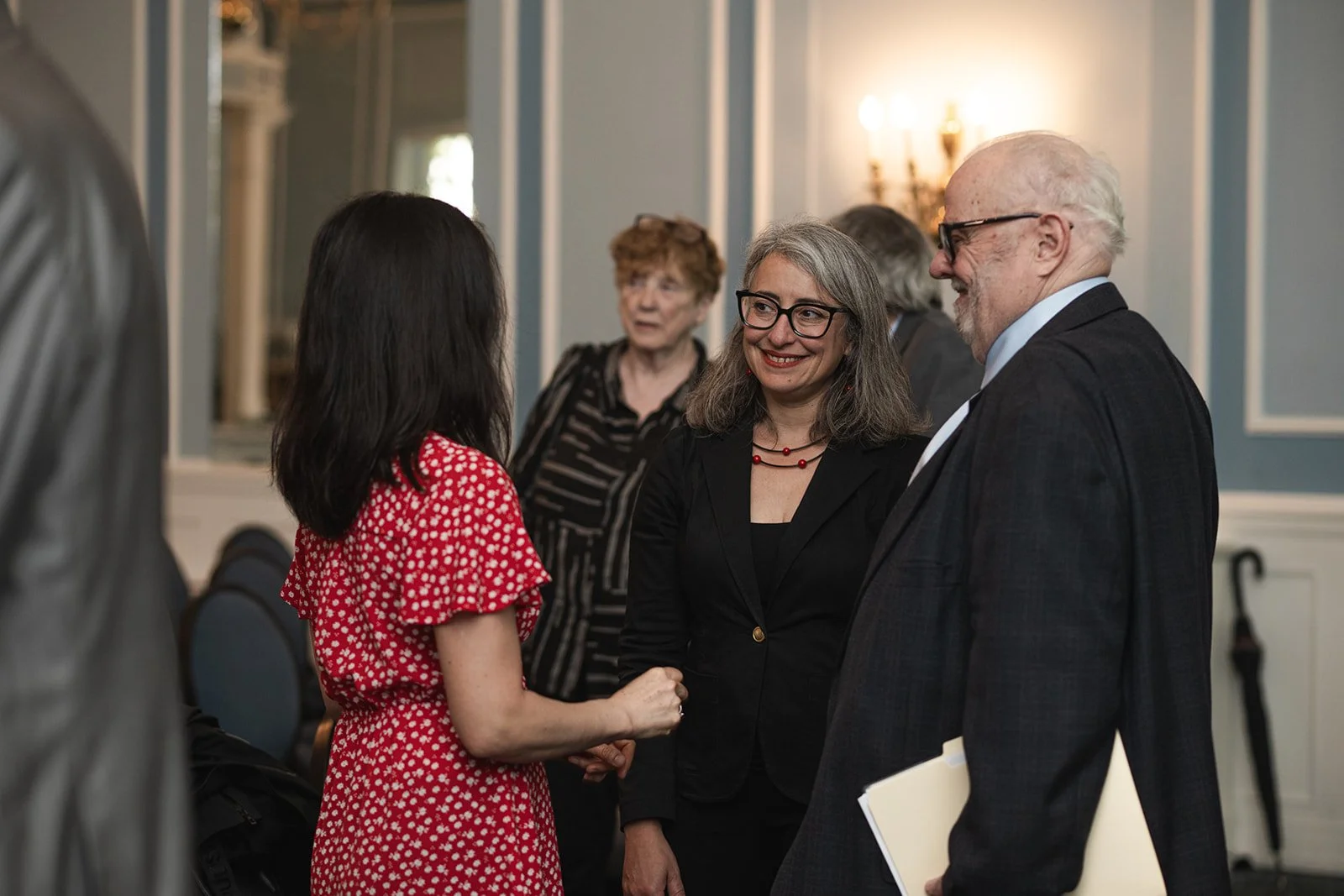 Group of people talking at a formal event in an at the U of T Faculty Building in Toronto.
