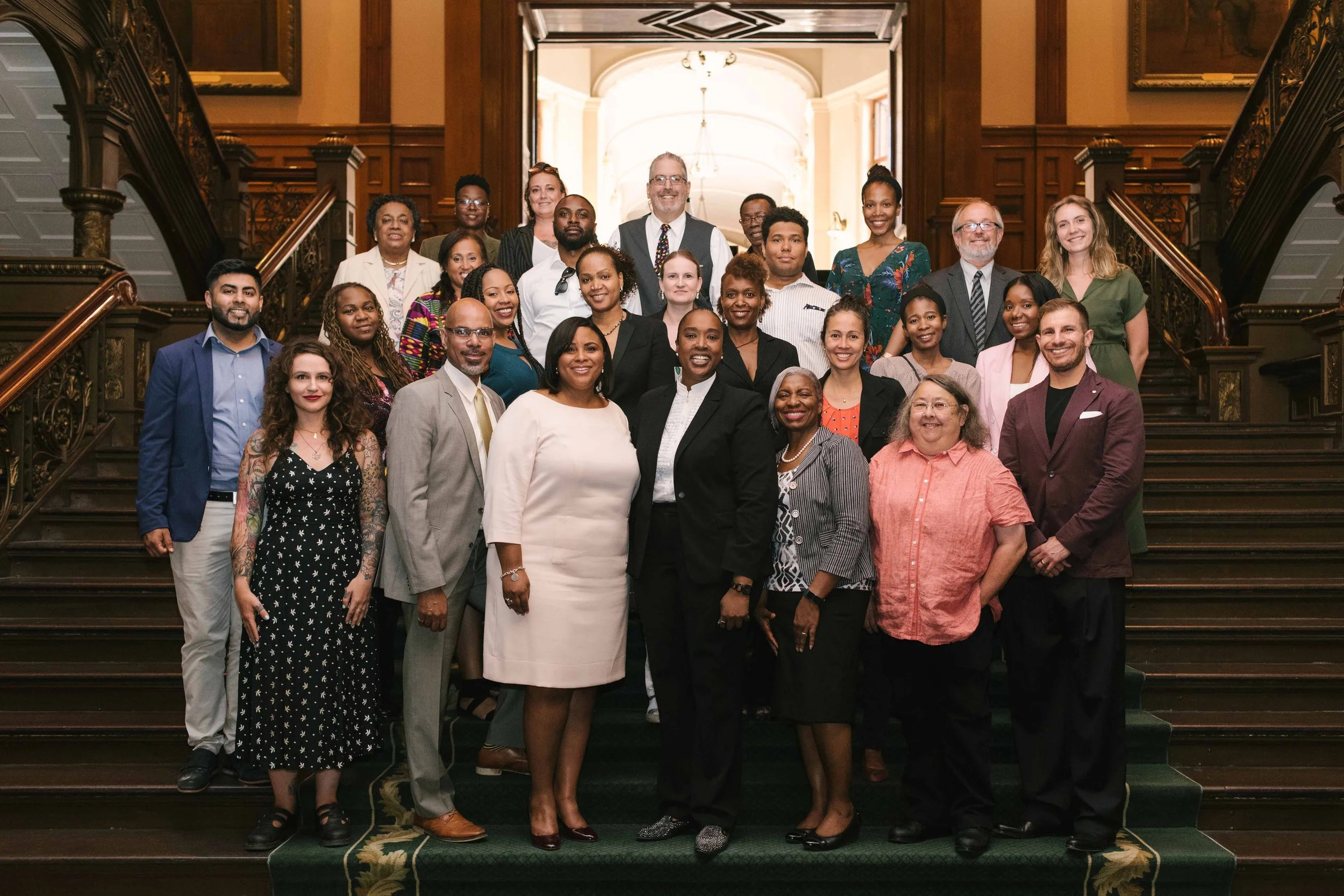 A group of people posing on a the main staircase inside Queens Park in Toronto.