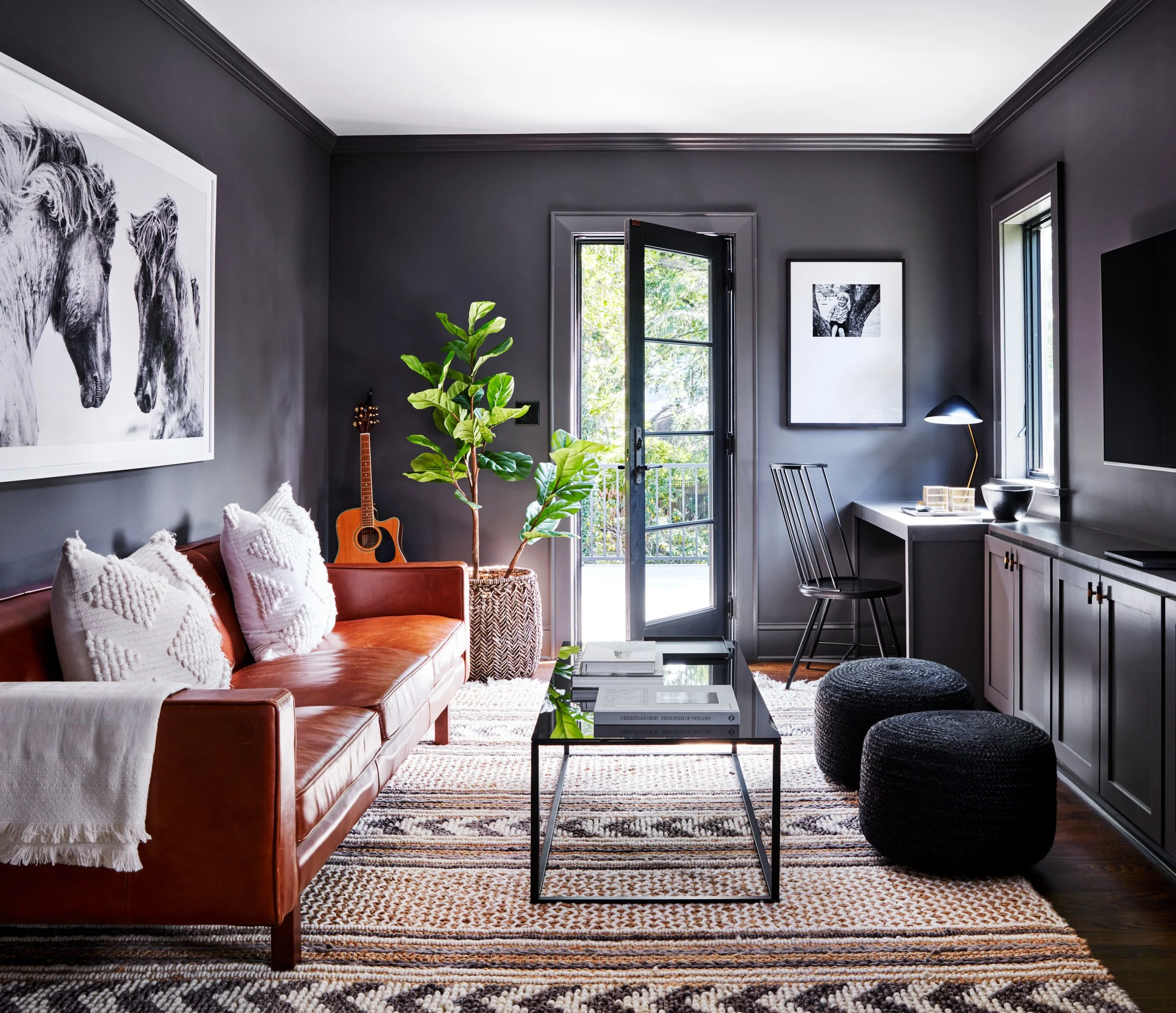 Moody living room with charcoal walls brown leather sofa textured rug and black accents
