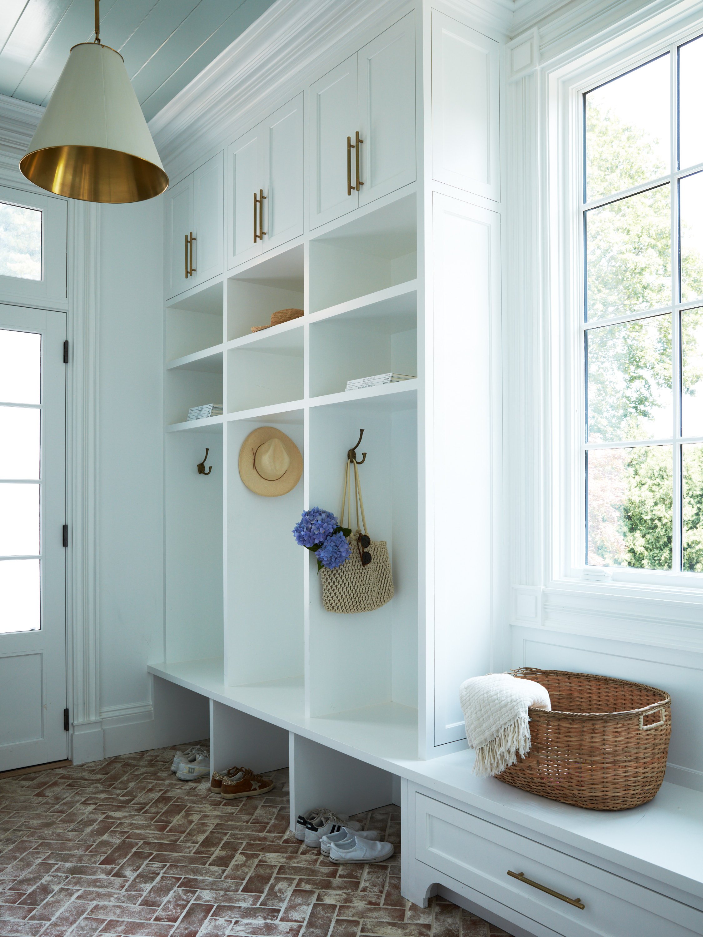 Custom built-in mudroom cubbies with brick flooring and functional storage.