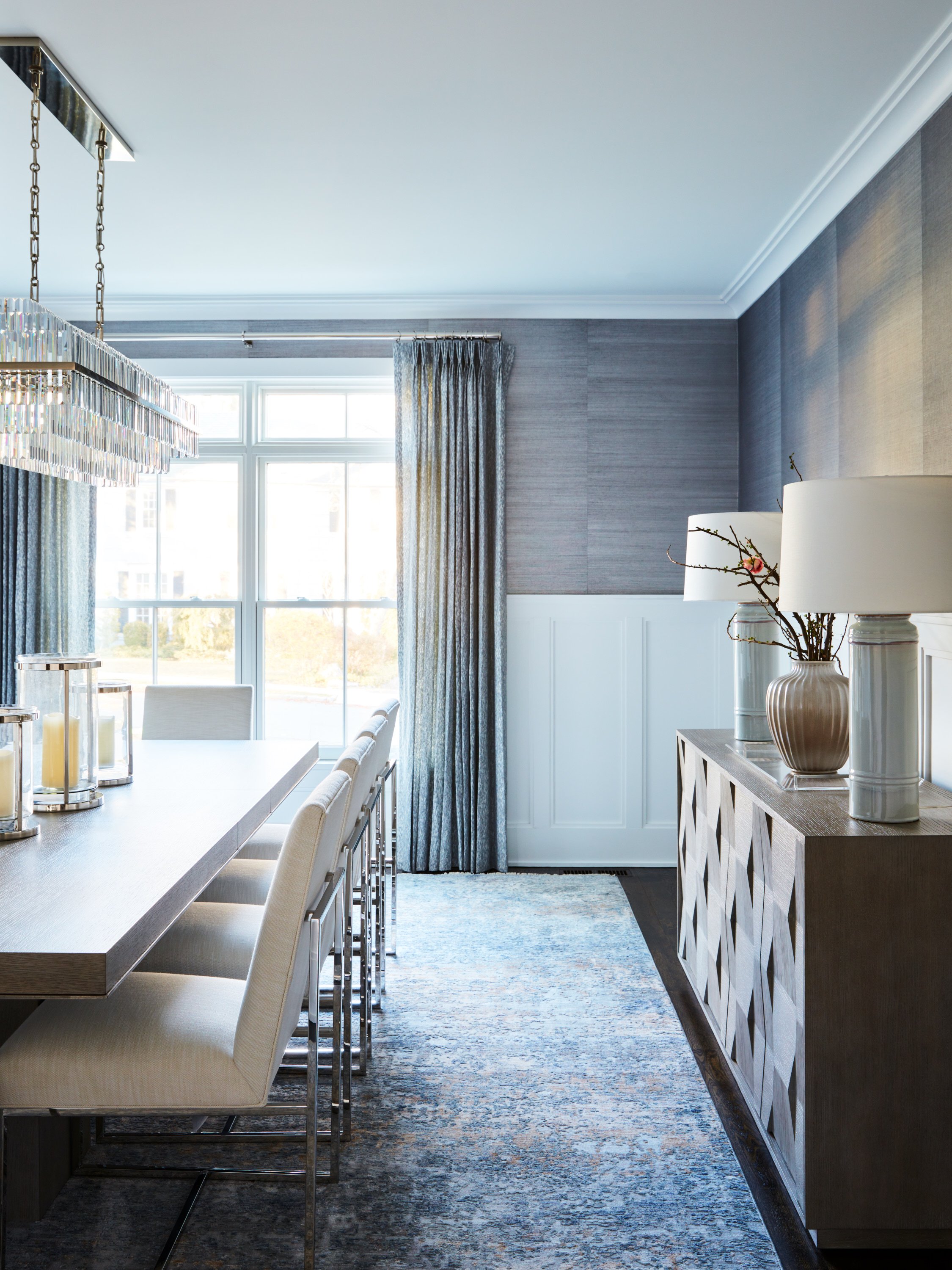 Blue drapery panels with tailored pleats in a traditional dining room.