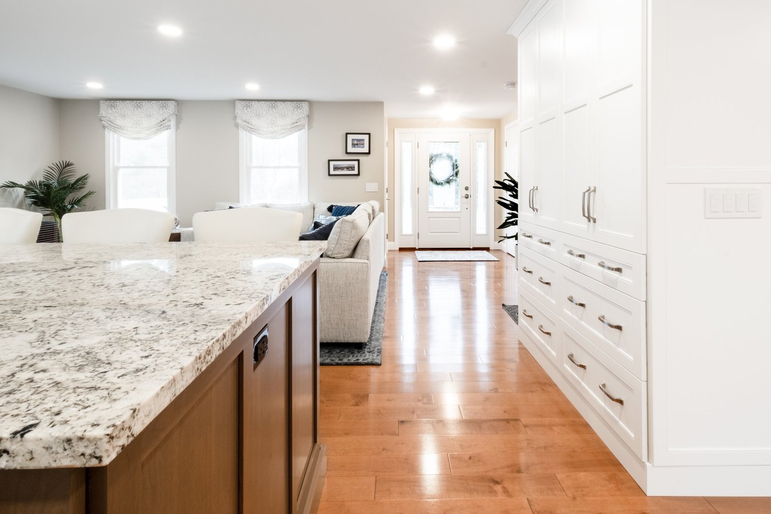 Kitchen island and full-height cabinetry with an open view through to the front door