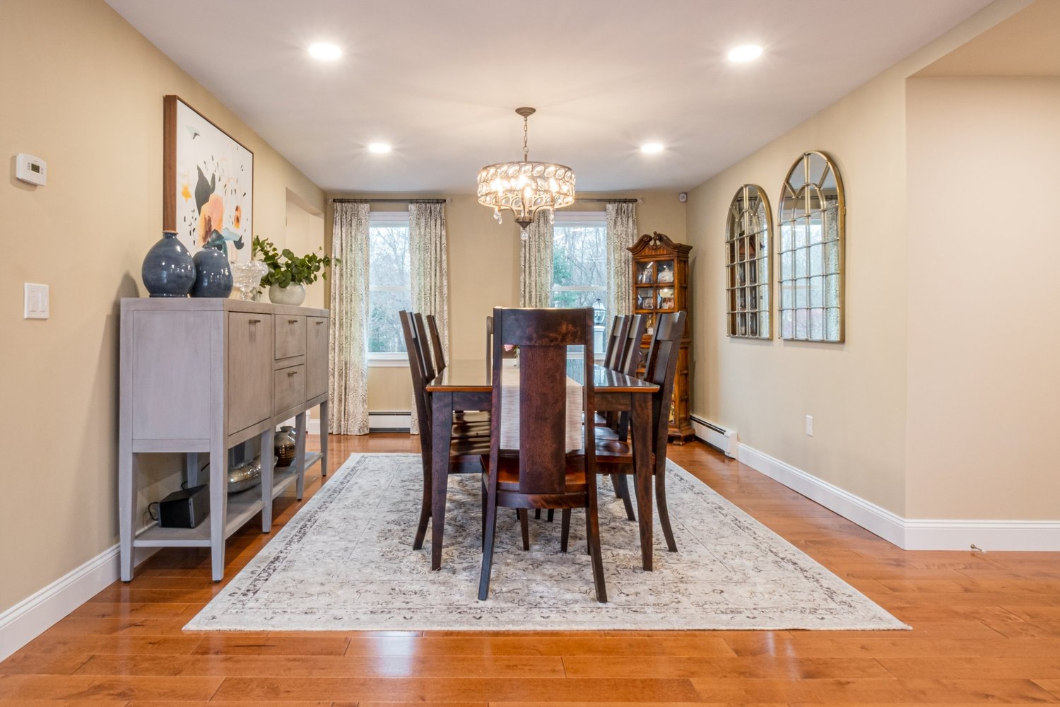 Formal dining room with a wood table, chandelier and wide plank wood floor