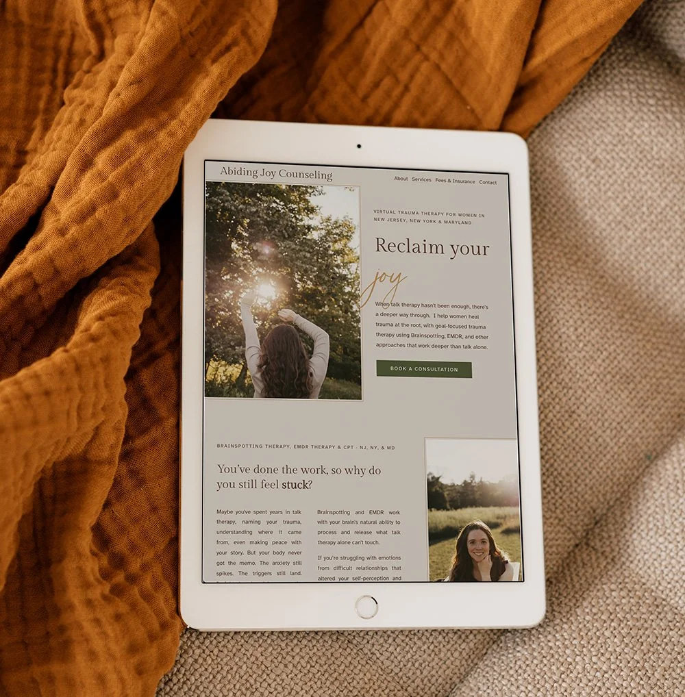 A therapist website featuring a photo of a woman holding up her arms towards the sun through trees, with sunlight shining through the leaves.