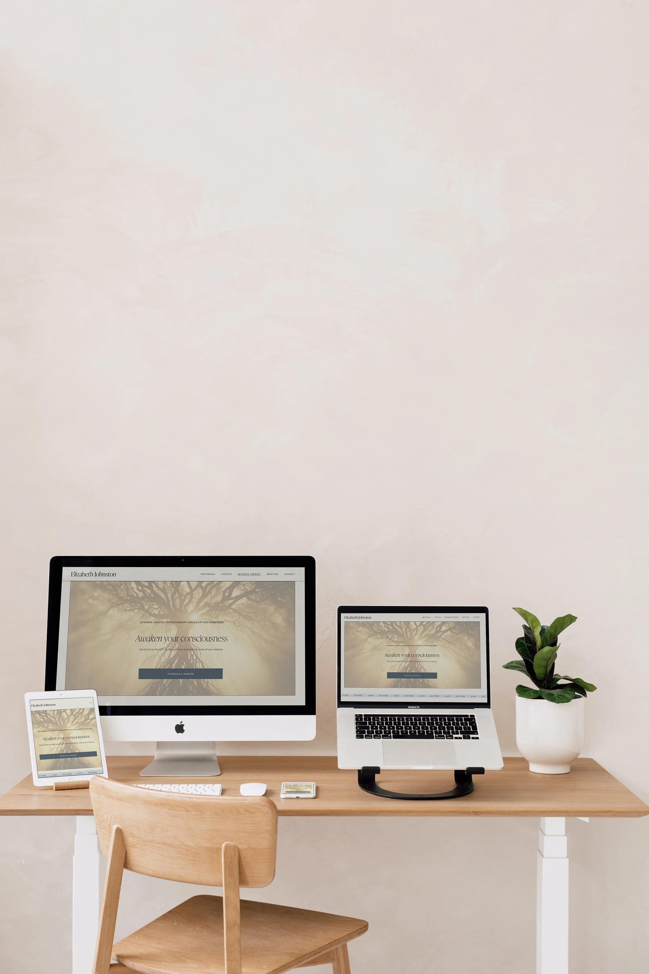 A desk with a monitor, laptop, tablet, and phone, each displaying a custom designed therapist website.