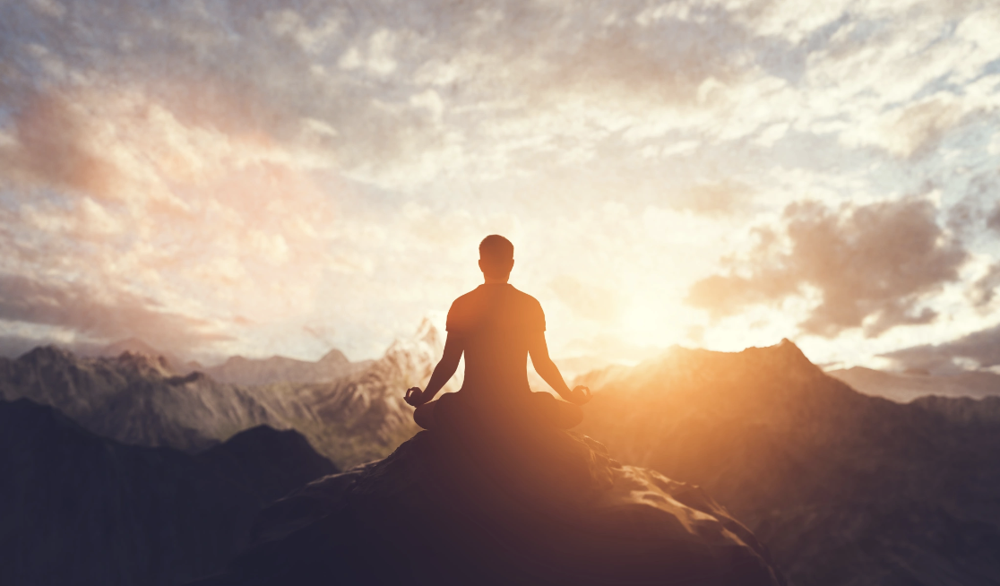 A silhouette of a man seated in a meditative lotus pose on a mountain summit with a radiant golden sunrise breaking through dramatic clouds and mountain peaks, representing the sense of grounded expansiveness and inner clarity cultivated through Mall