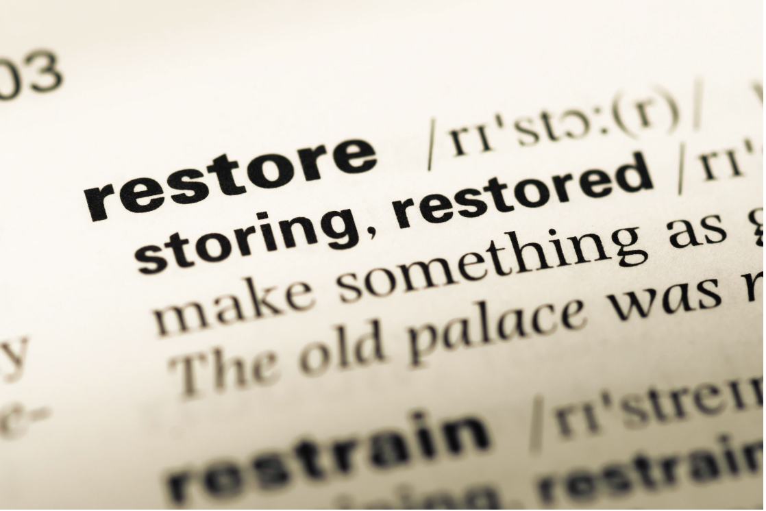 Close-up of a dictionary entry for the word restore, representing the restorative approach to nervous system regulation and trauma healing at the core of Malachi Gillihan's integrative practice and Nervous System Reset offerings