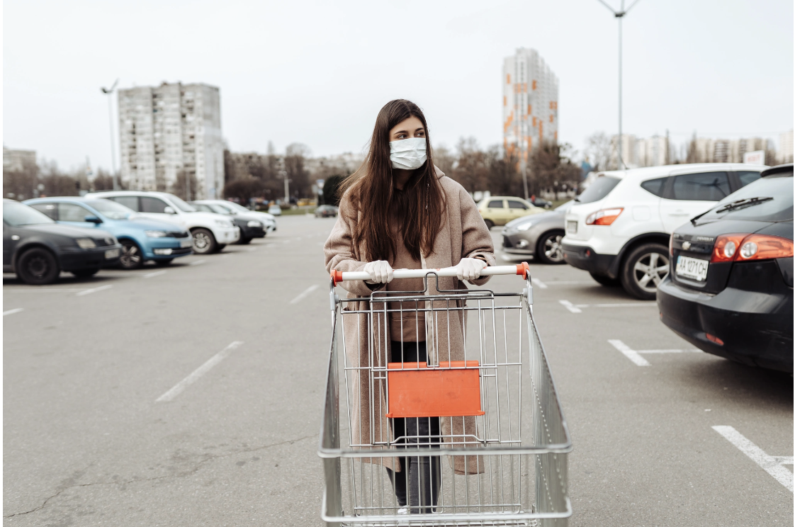 A woman pushing a shopping cart through a parking lot on an overcast day, representing the way unresolved trauma can affect everyday tasks, energy levels, and engagement with daily life
