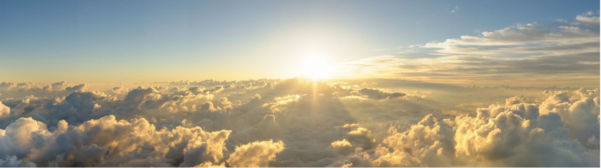 A panoramic aerial view of a radiant sunrise breaking above a vast sea of golden clouds, evoking the sense of emergence, hope, and renewal that is possible through the trauma healing journey with Malachi Gillihan