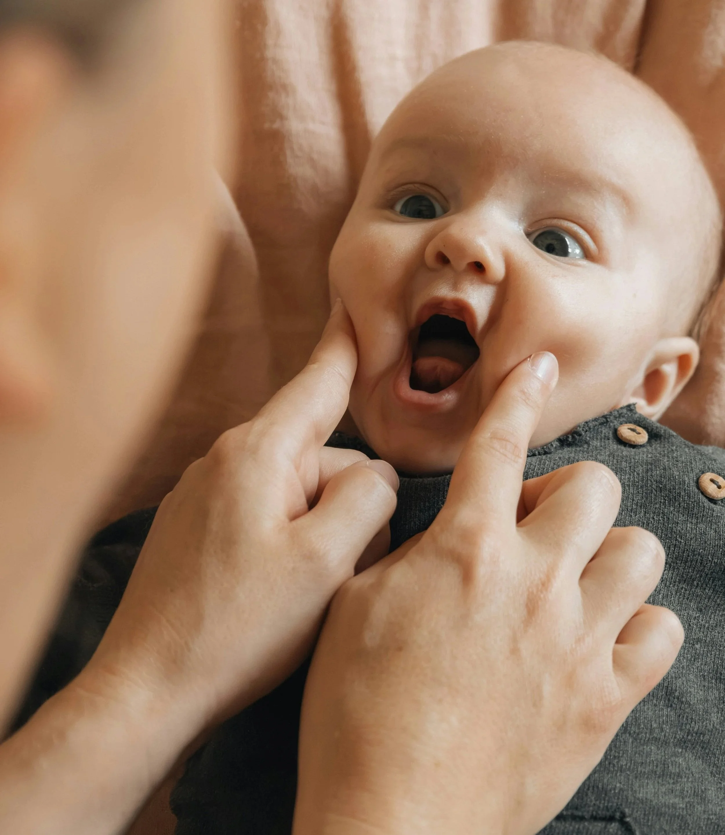 parent looking in baby's mouth to check for ties