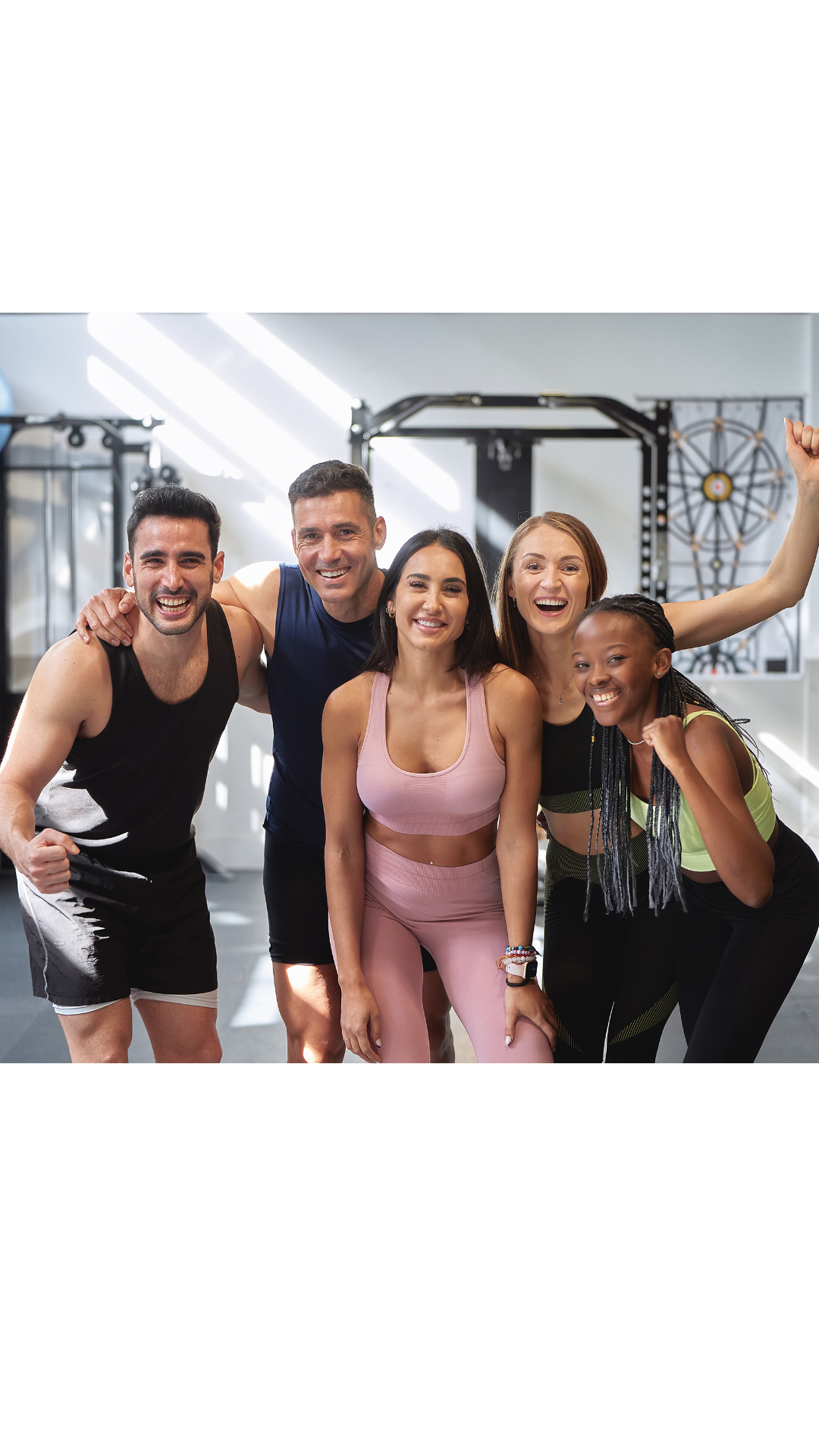 Group of coworkers smiling after a group fitness class in a modern office gym, representing onsite wellness and tenant engagement programs.