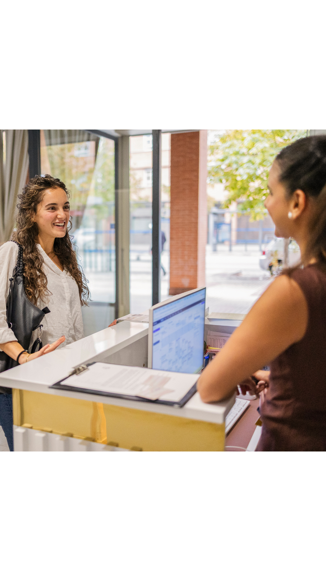 Property staff member welcoming a tenant at a modern office building front desk, representing tenant experience and community engagement in commercial properties.