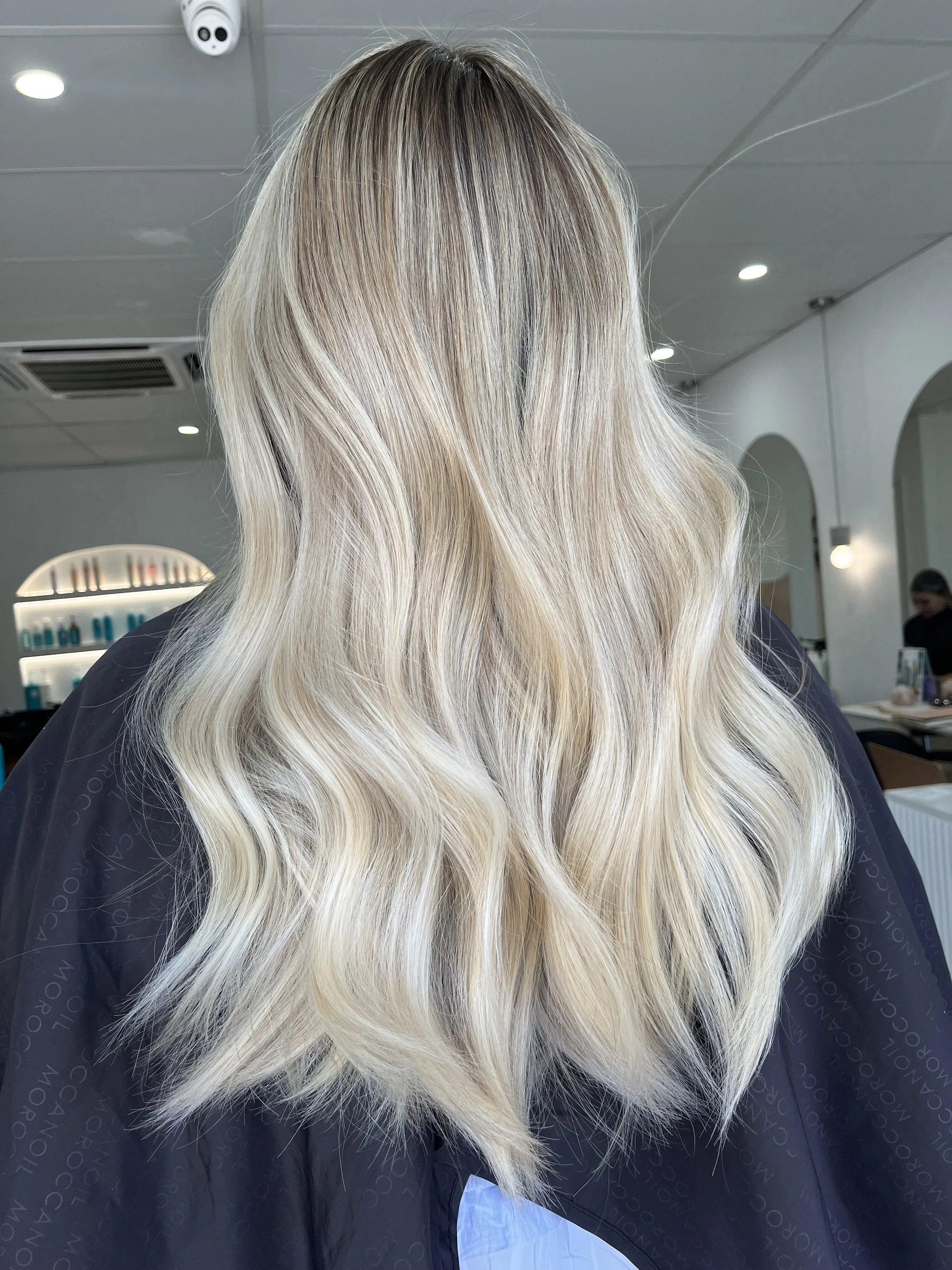 Blonde woman with wavy hair in a salon or hair studio.