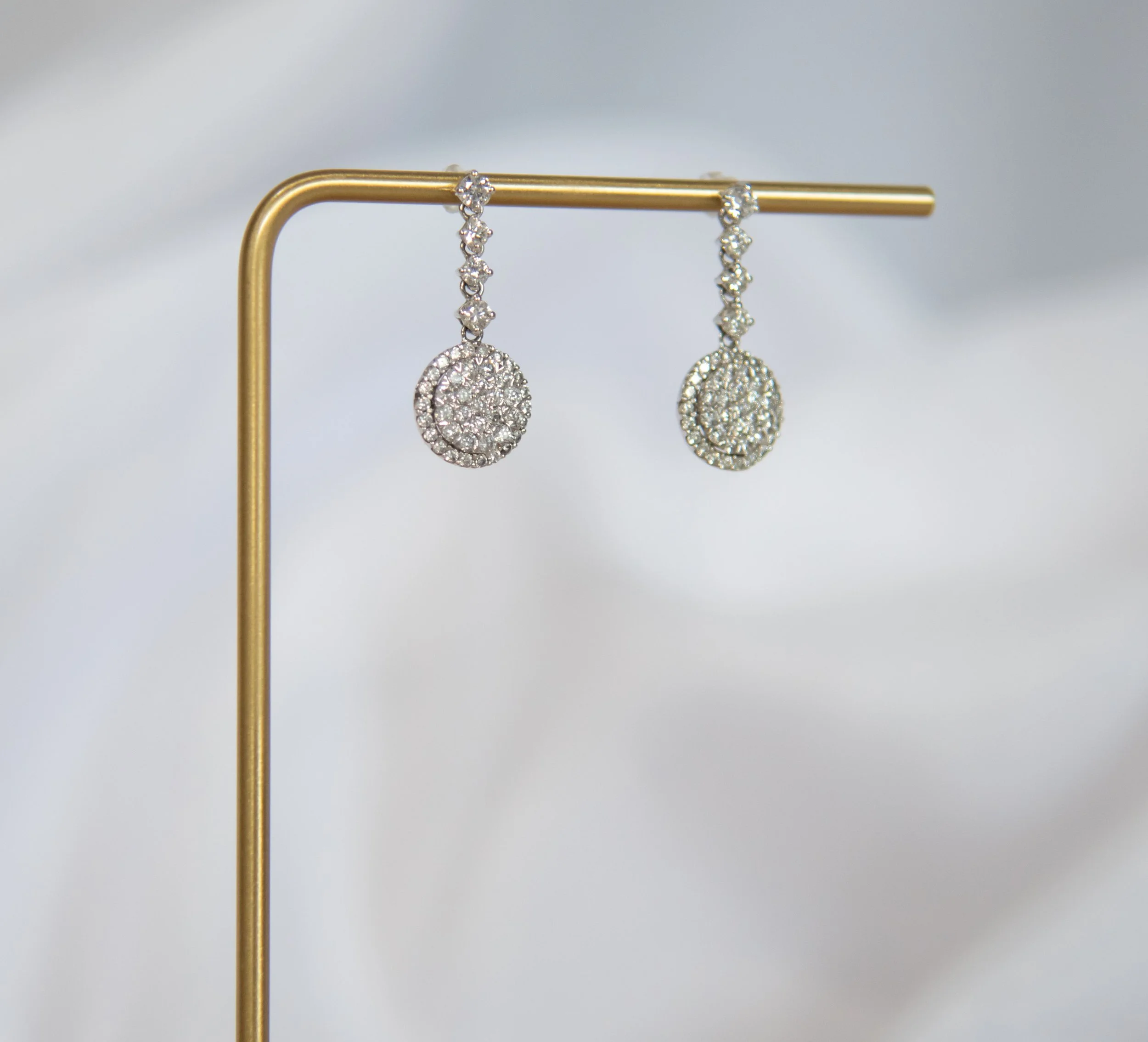 A pair of diamond cluster dangle earrings.