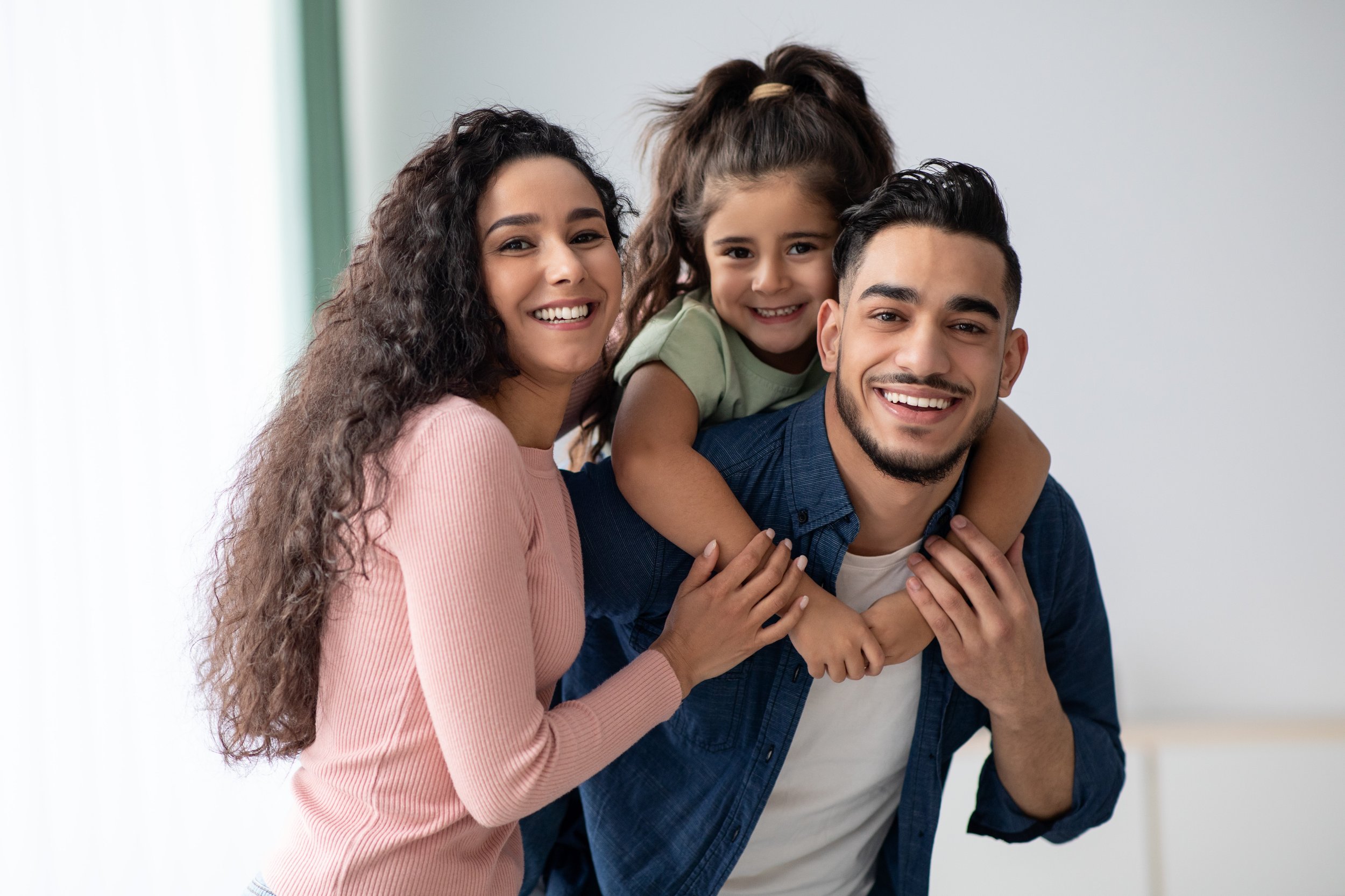portraif-happy-young-arabic-family-three-with-little-daughter-middle-eastern-mom-dad-kid-having-fun-while-posing-home-parents-enjoying-spending-time-with-their-child-free-space.jpg