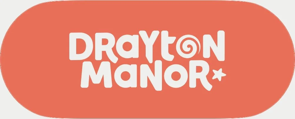 Oval logo with a coral background and white stylized text reading "Drayton Manor" with a spiral and star embellishments.