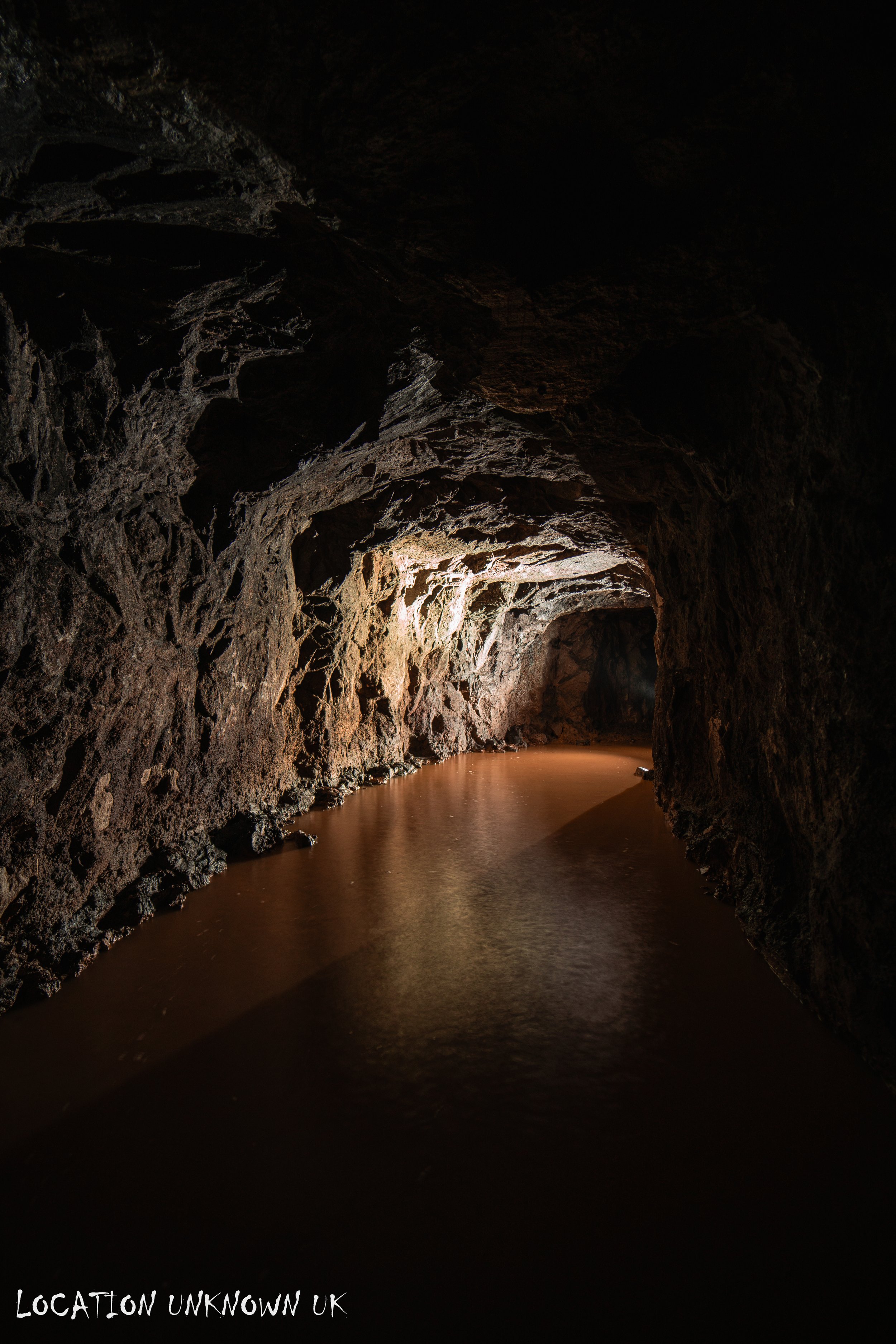 At the top of the ladders the passage is partially flooded and leads to a tipping shaft to the right.