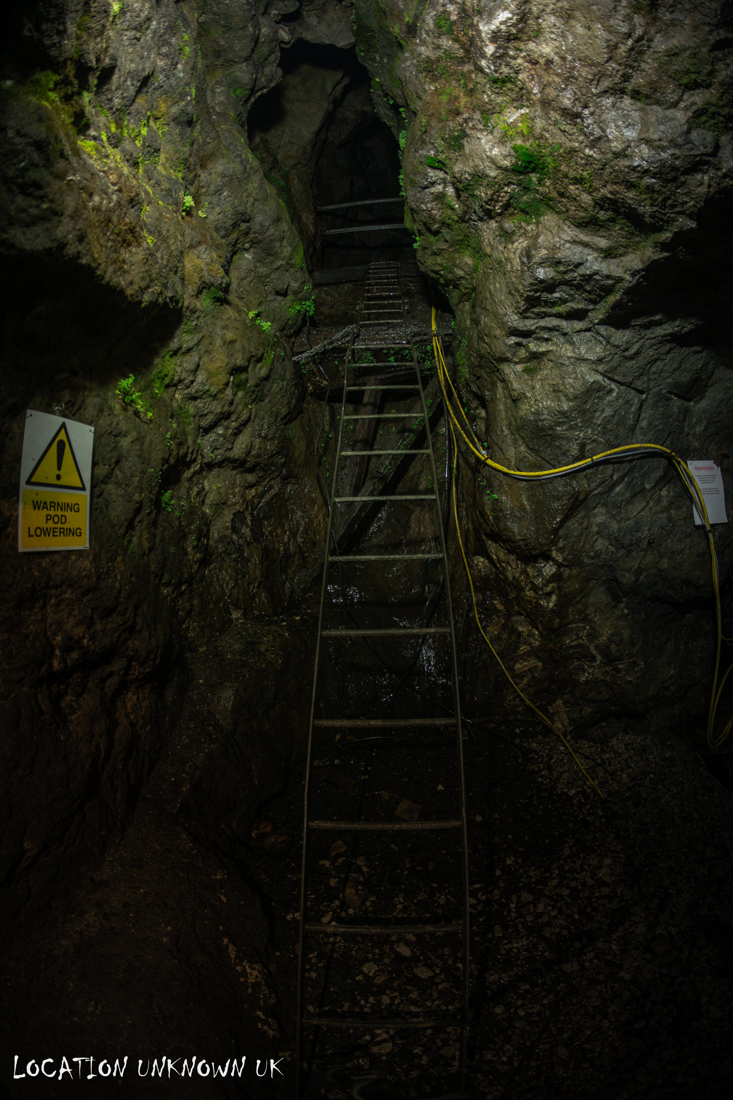 This ladder leads to the original 'Black Engine Shaft' which is now used as an emergency shaft. Above ground in a small shed building is a winch which if needed would bring people up to the surface. Ladders lead part way up the 90m shaft from the ba