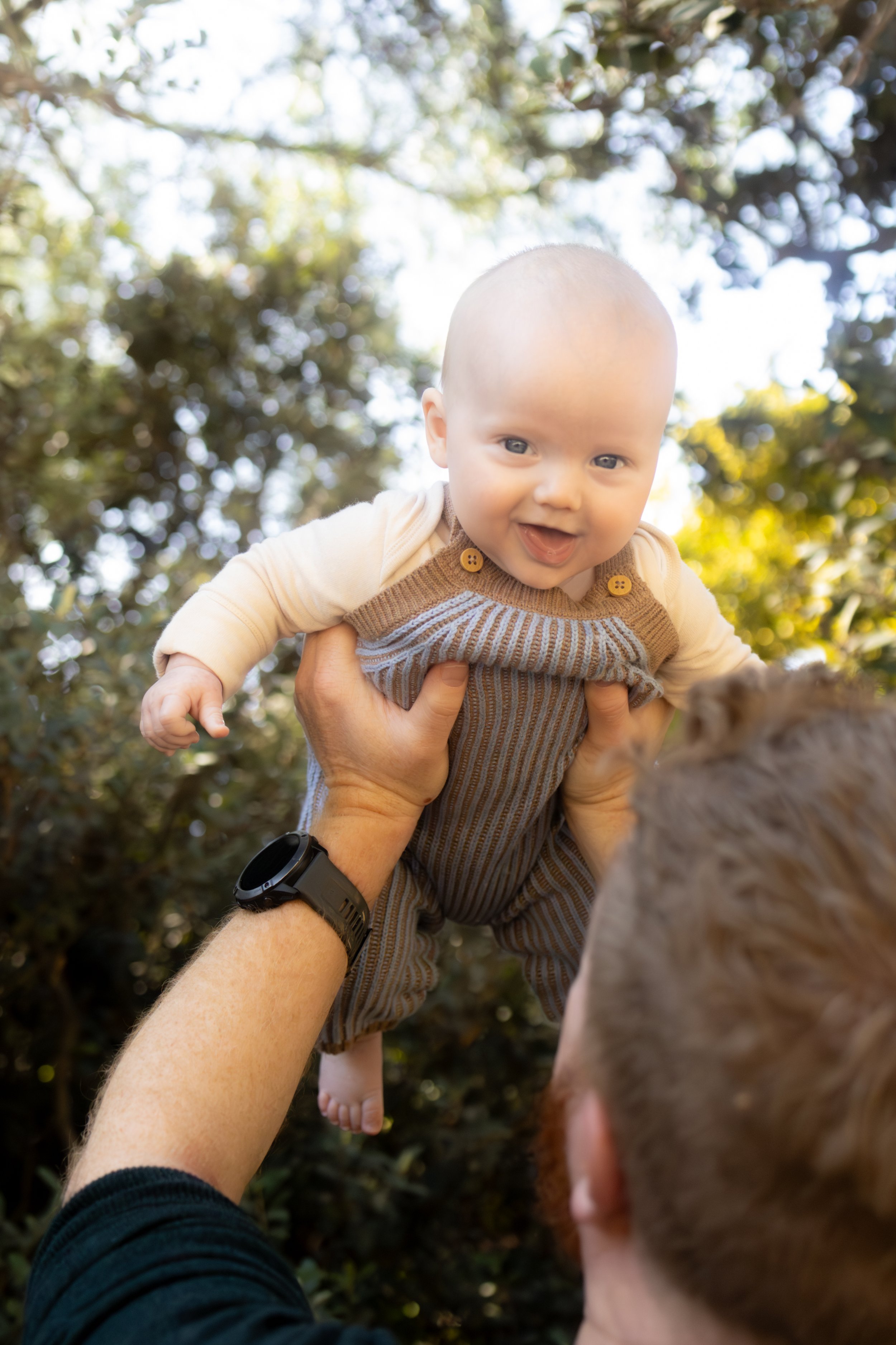 baby being thrown in the air from dad