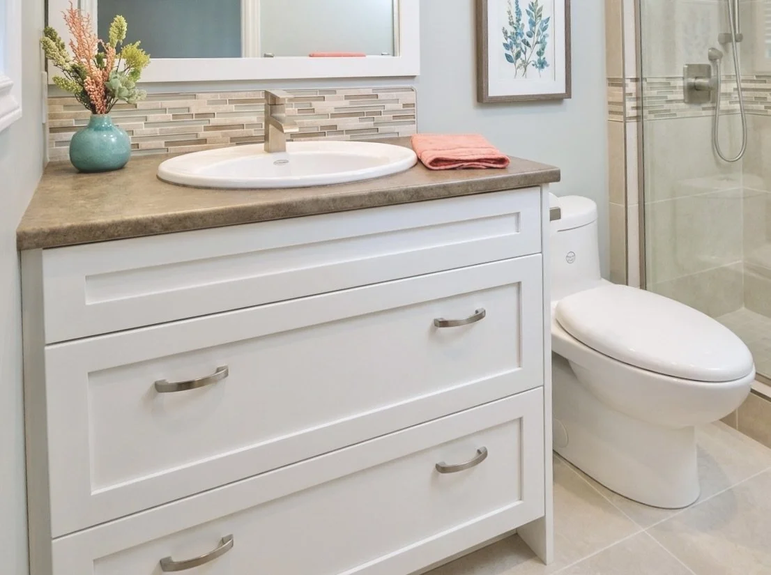Custom white shaker-style bathroom vanity with brown laminate countertop and brushed nickel hardware by Bob & Mark's Custom Cabinets, Pembroke Ontario