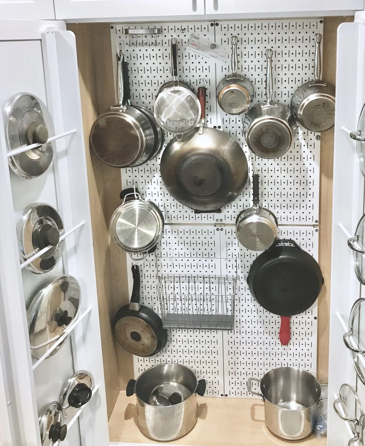 Custom kitchen cabinet with built-in pegboard pot and pan organizer and lid storage racks by Bob and Mark's Custom Cabinets Pembroke