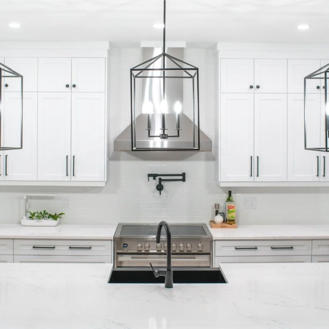 Two-tone white and grey shaker kitchen with quartz island black sink and stainless range hood Ottawa Valley