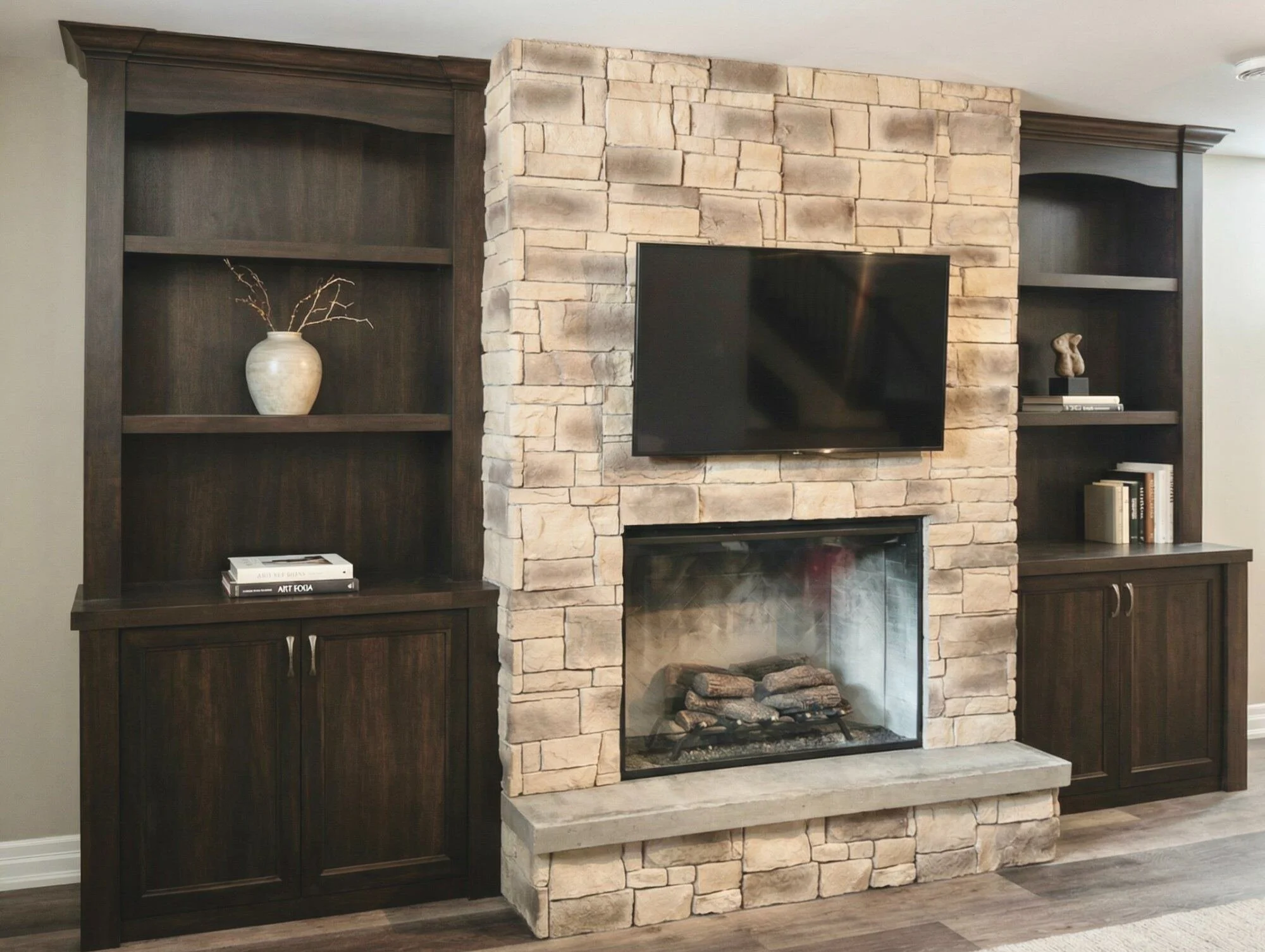 Custom dark stain built-in bookshelves and cabinets flanking stone fireplace by Bob and Mark's Custom Cabinets Pembroke