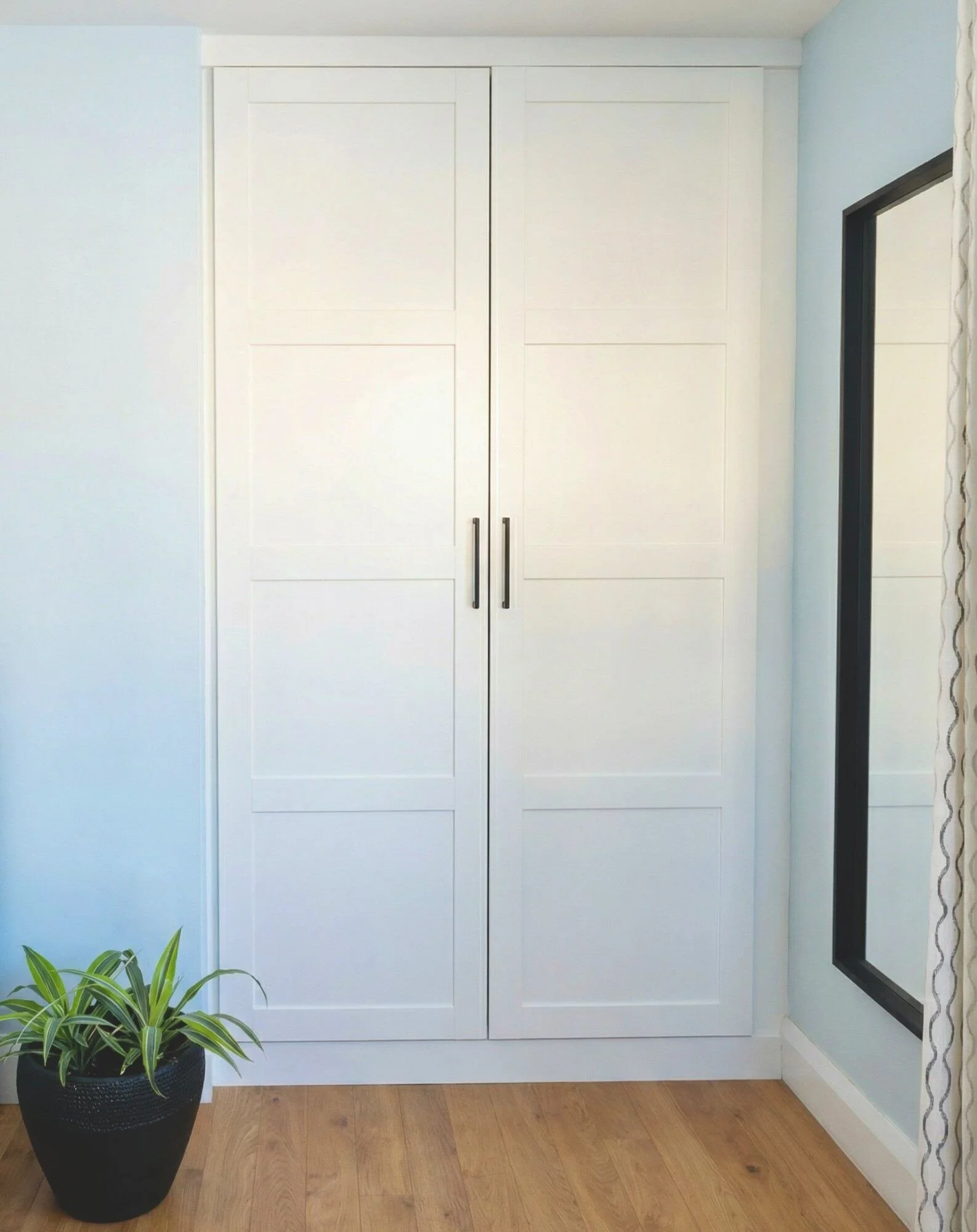Custom white shaker-style built-in wardrobe with brushed nickel handles by Bob and Mark's Custom Cabinets Pembroke