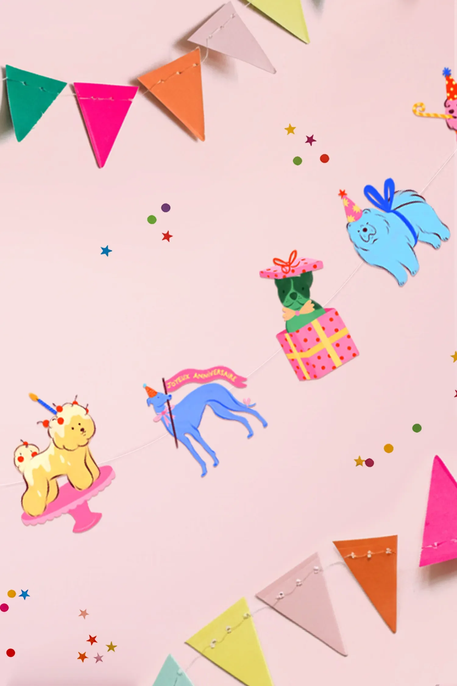Décoration de fête sur un mur rose avec des guirlandes de fanions colorés et des papillotes décoratives avec des animaux et des fêtes d'anniversaire.