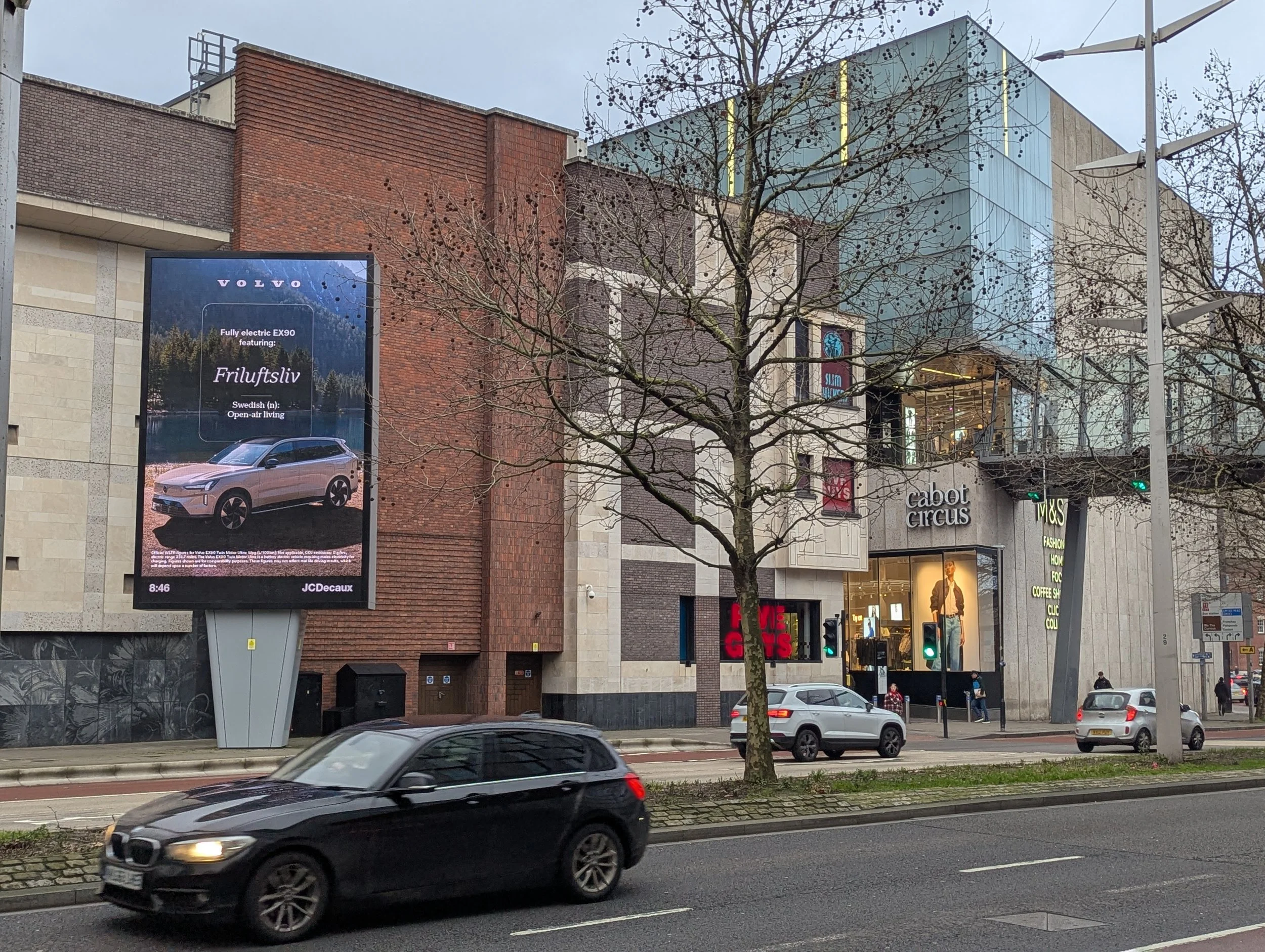 A large digital billboard shows an advert for an SUV.
