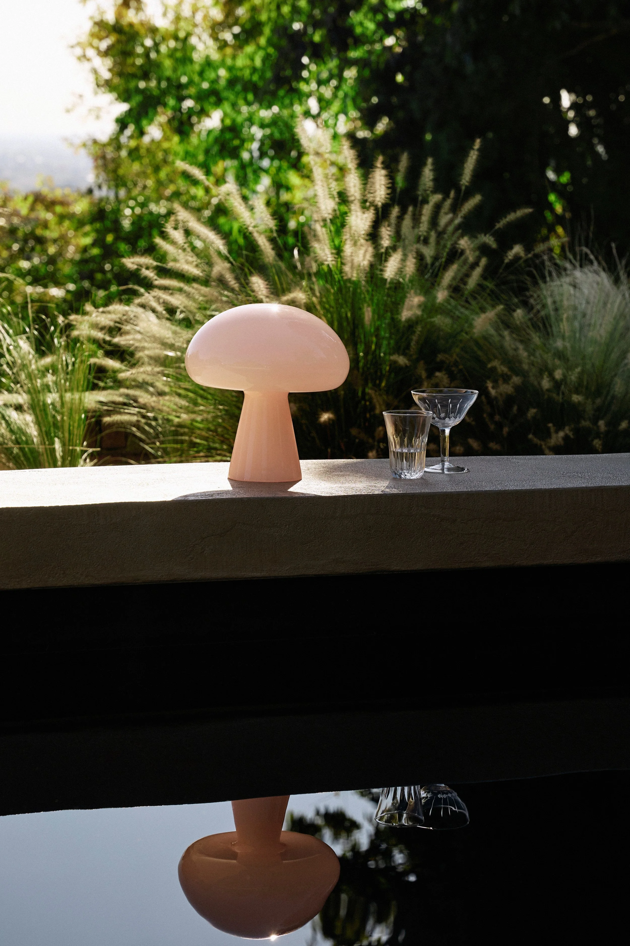 GUBI garden light lifestyle shot by pool _SS26_Lifestyle_09.jpg