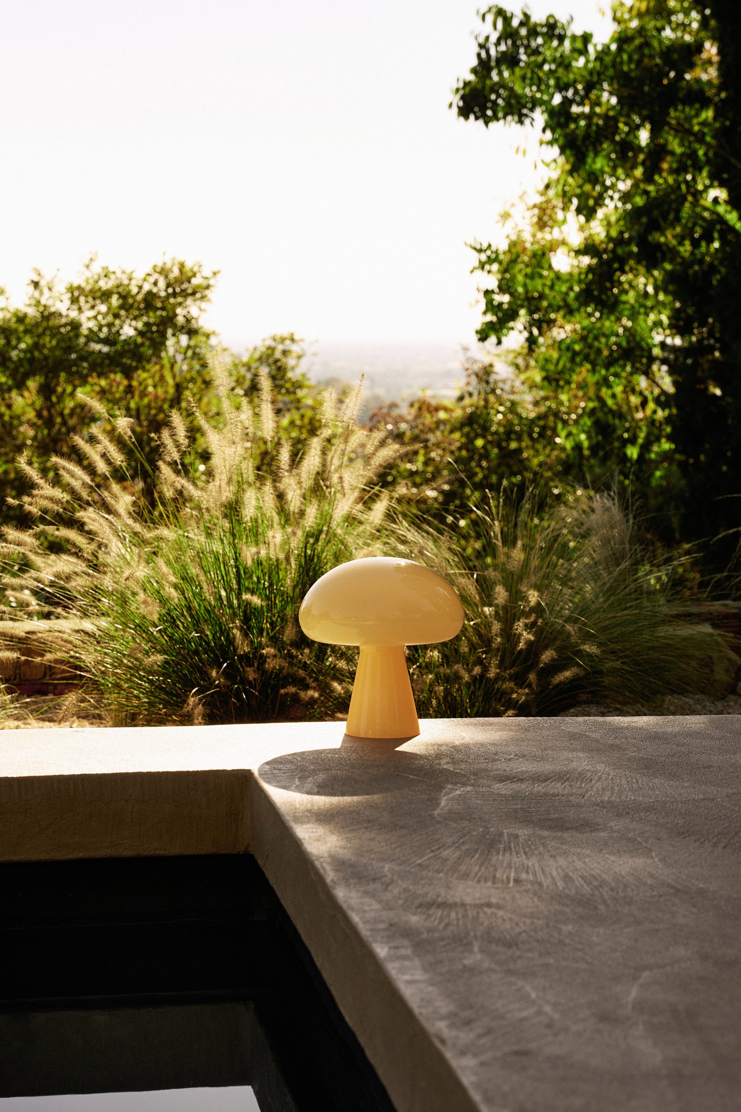 GUBI garden light lifestyle shot by pool_SS26_Lifestyle_07.jpg