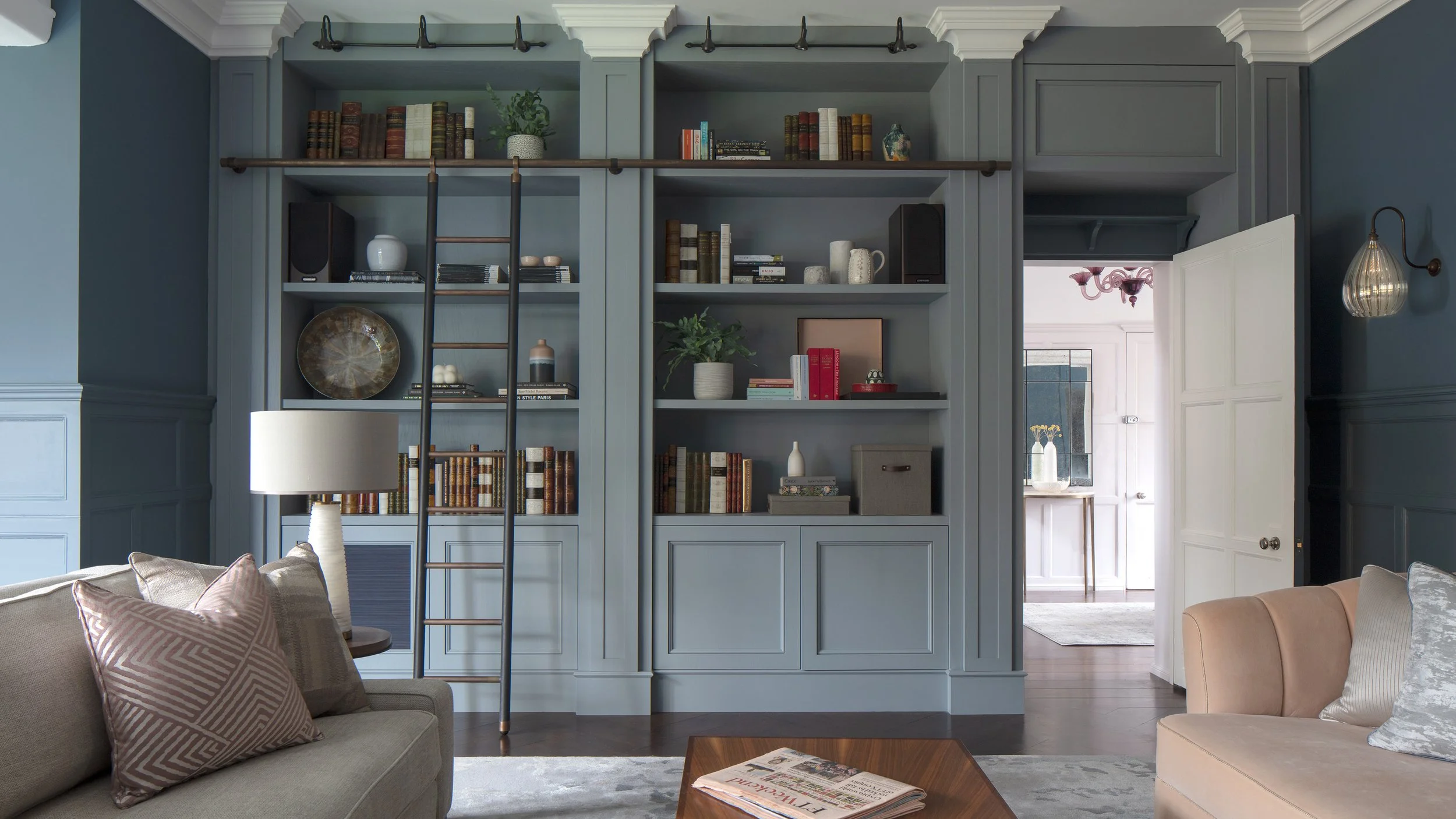 Roselind Wilson Design interior featuring layered timber, warm earthy tones and bespoke furniture in a London prime residential project Blue library shelves