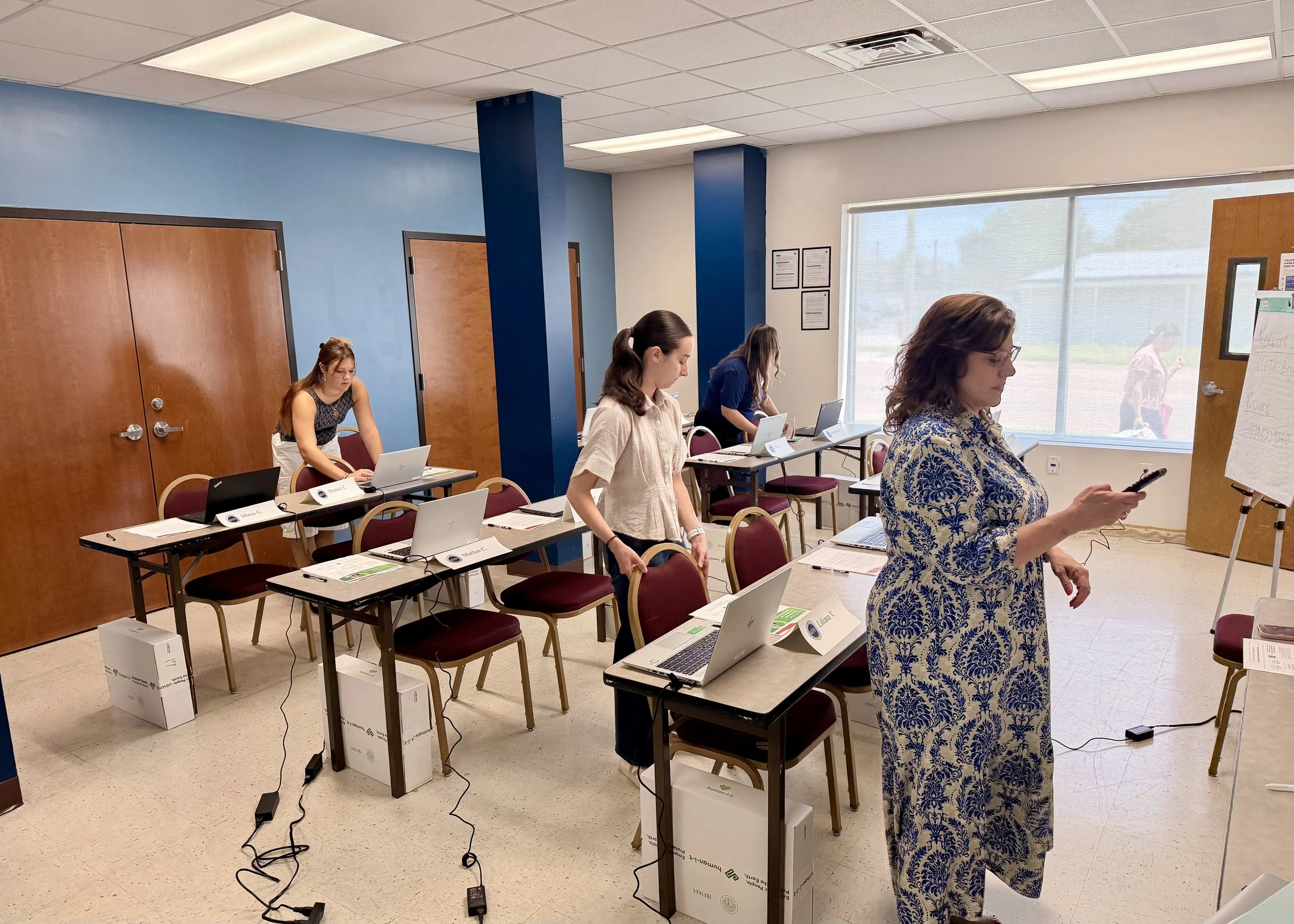 St. Gabriel's Pregnancy and Parenting Program Director, Debbie Haney, along with Texas A&M University students Sarah Schoppe and Emma Powell, finish setting up a Digital Literacy Workshop class at Catholic Charities of Central Texas.