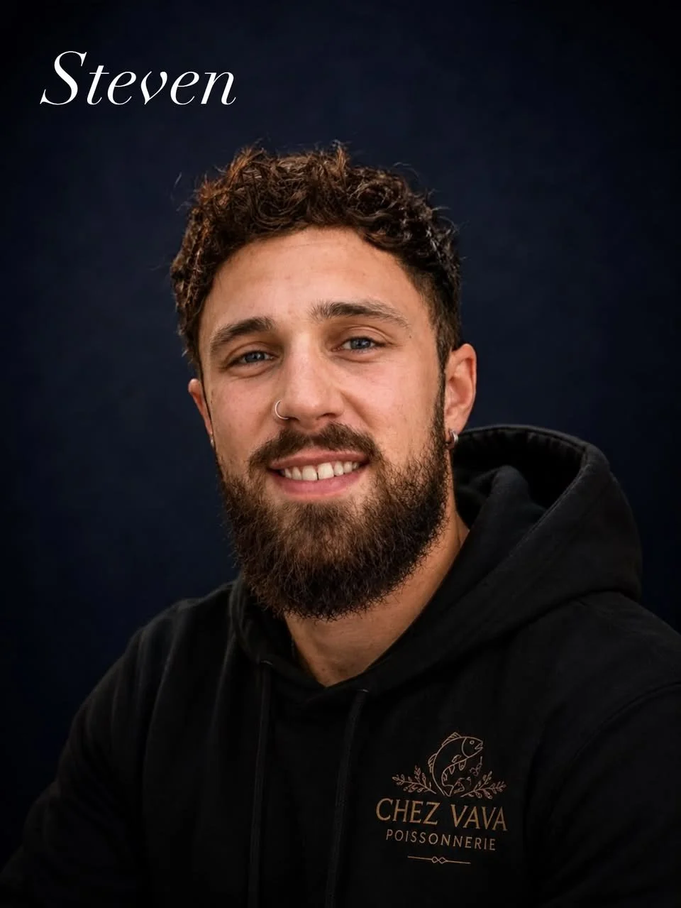 Portrait d'un homme aux cheveux bouclés, barbe et bouclé, portant un sweat noir avec le logo "Chez Vava Poissonnerie". Fond noir. Texte "Steven" en haut à gauche.