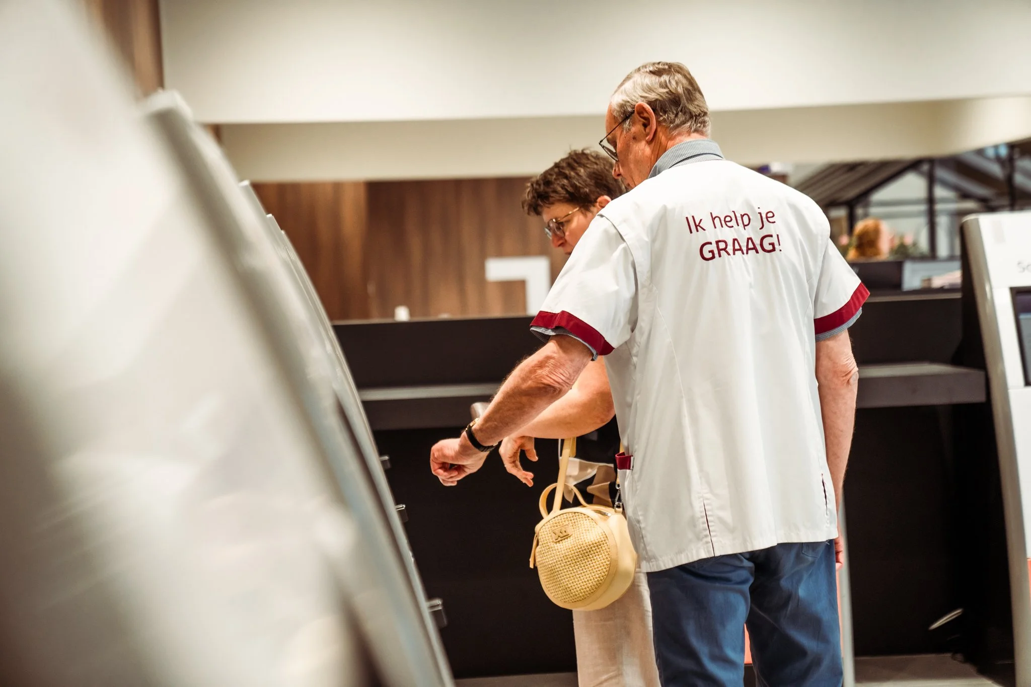 Medewerker met t-shirt 'ik help je graag!'