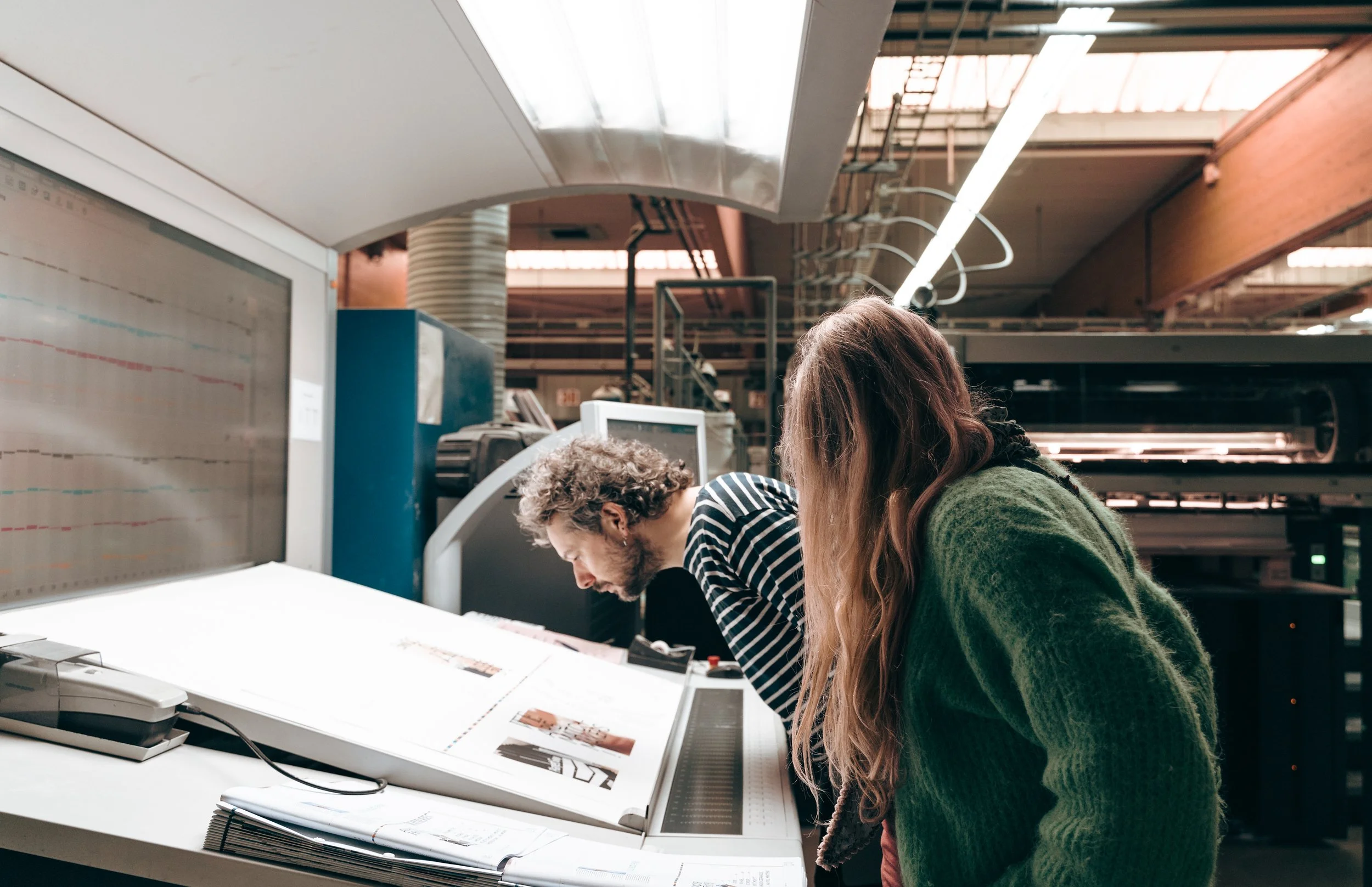 Personen kijken details na van gedrukte pagina's.