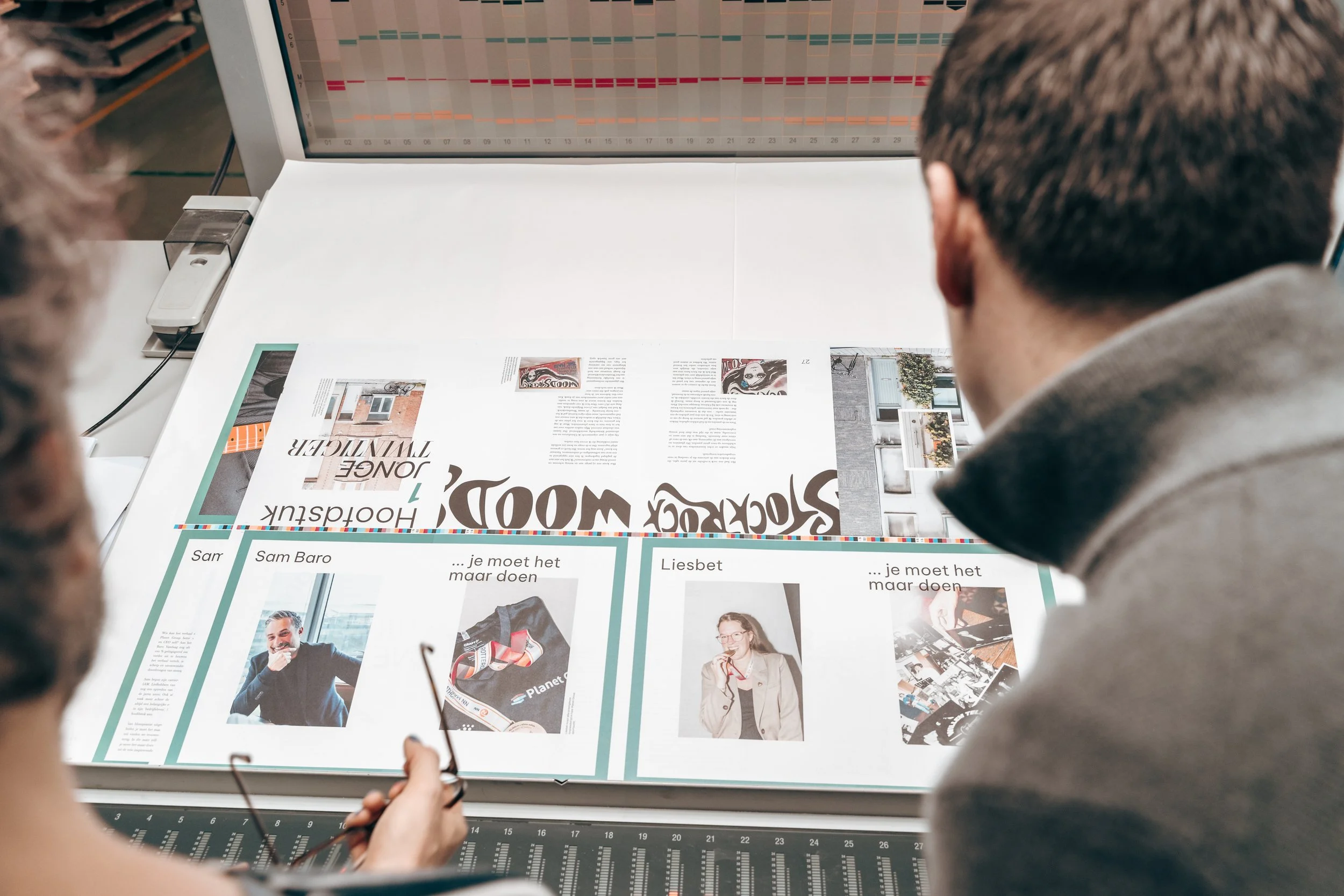 Personen bekijken de gedrukte pagina's. Foto is genomen vanuit het standpunt van de personen.