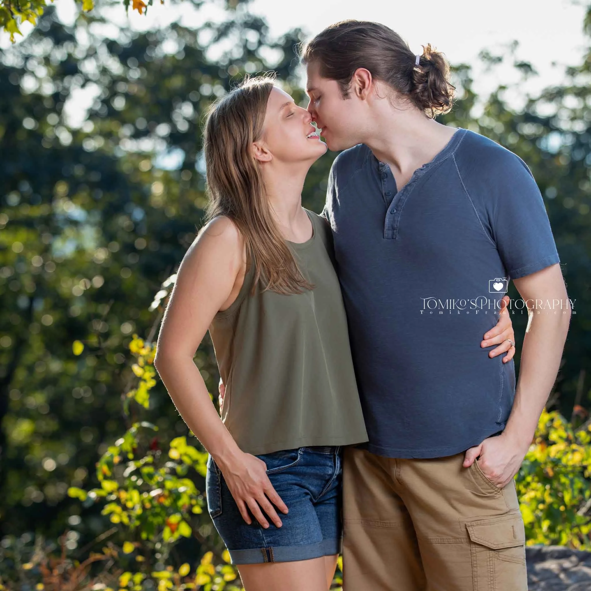 He kneels to propose at Oak Mountain’s scenic ridge, photographed in a warm‑luxury Birmingham AL style.