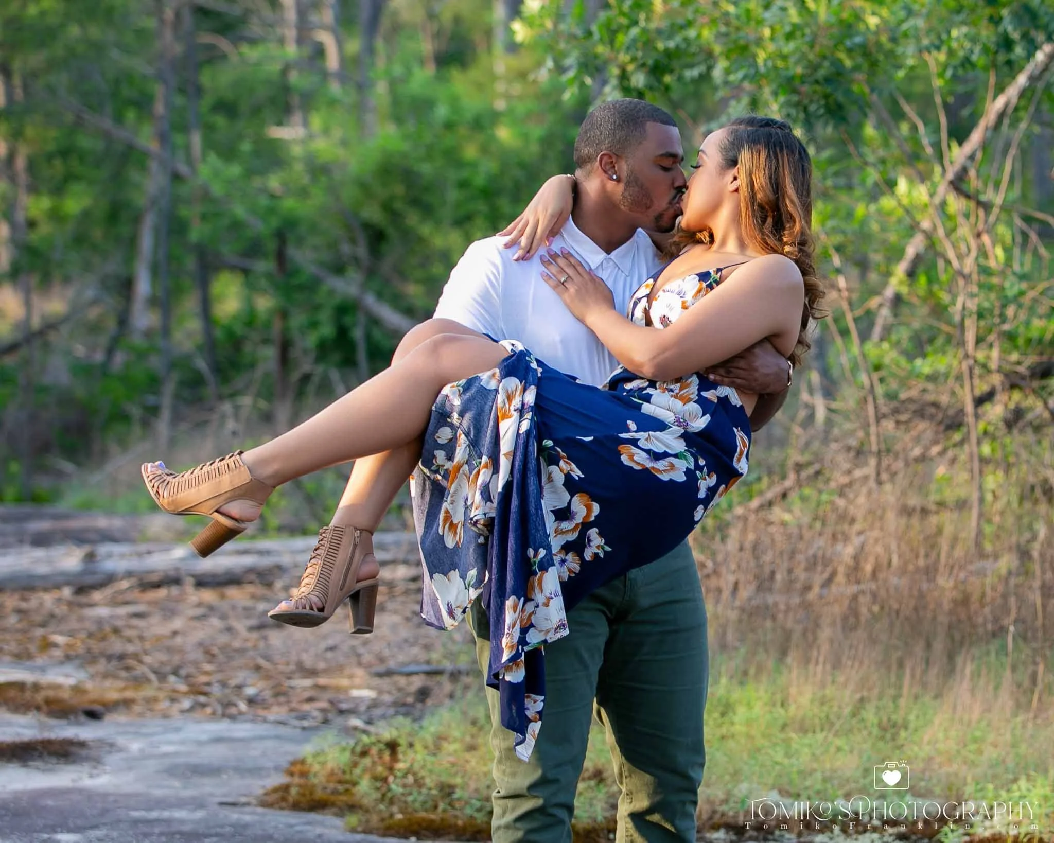 Engagement photo of a man holding a womn and kissing