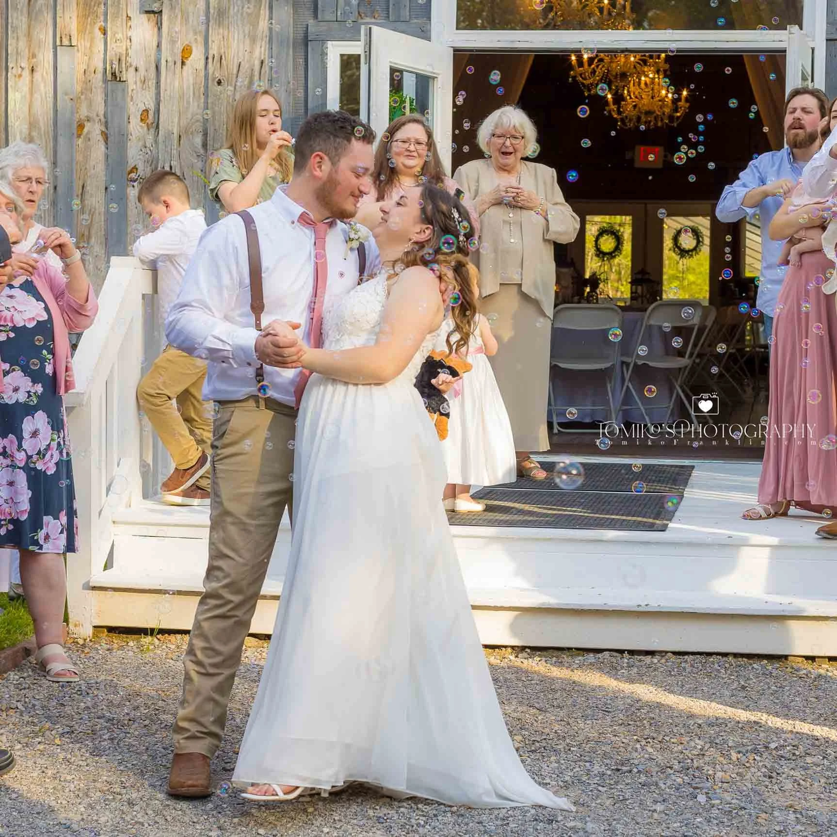 Bride and groom dipping and smiling after their wedding while guests cheer around them. Captured by Tomiko’s Photography, this joyful Birmingham AL wedding moment blends elegant editorial artistry with timeless, romantic storytelling.