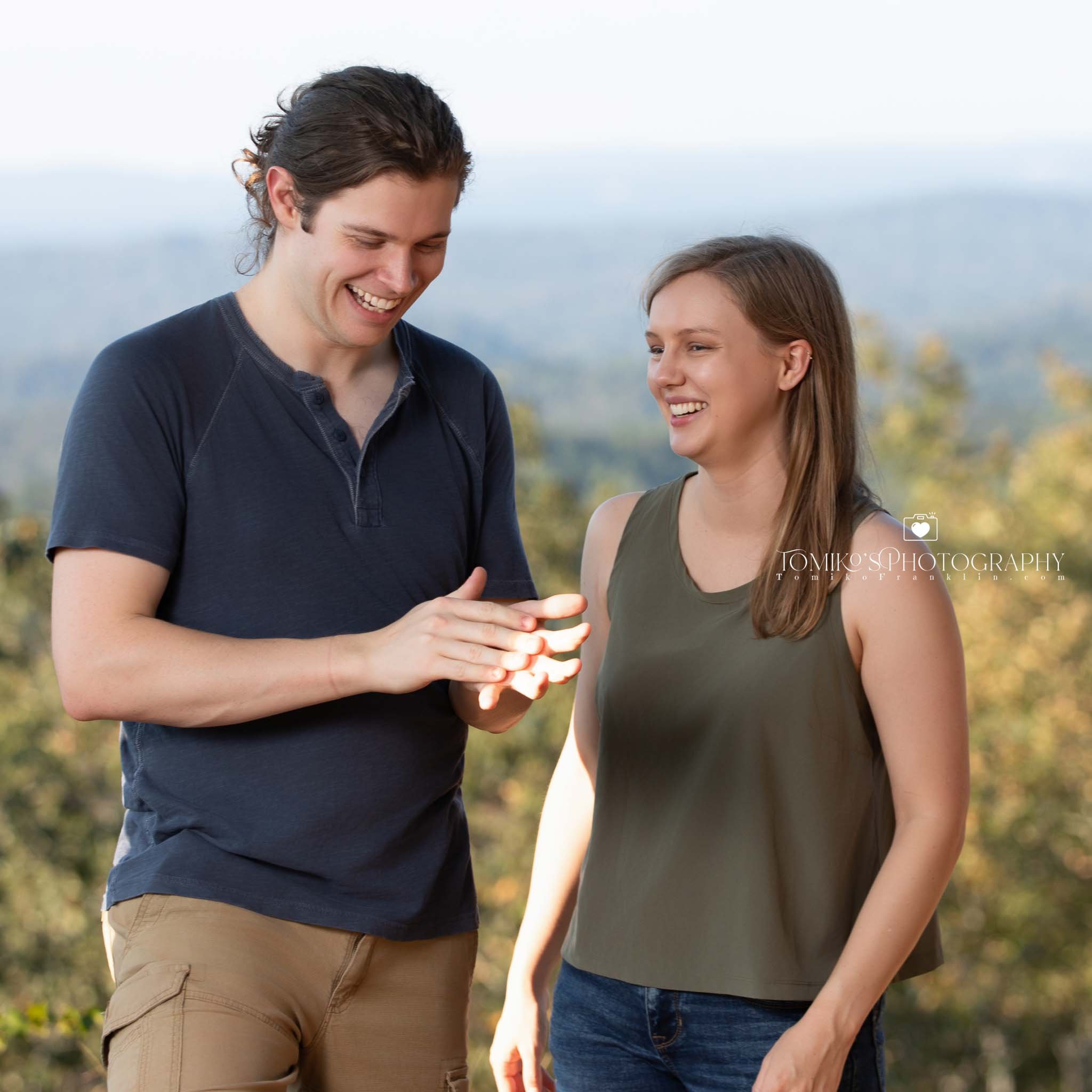 Candid reaction during a surprise proposal at Oak Mountain State Park with lush greenery and soft light.
