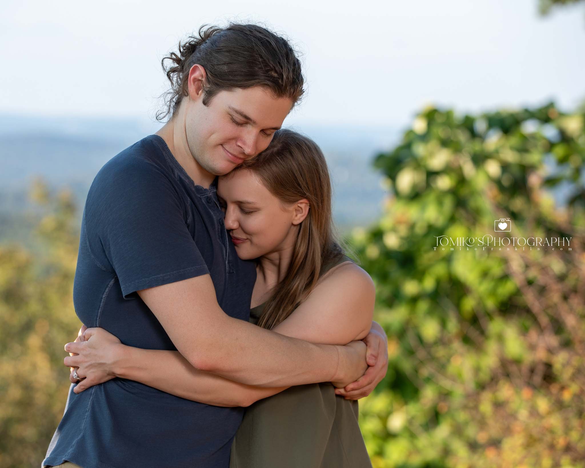 Newly engaged couple embracing at sunset in Birmingham, AL, photographed by Tomiko’s Photography with soft posing and warm, luxury engagement styling.