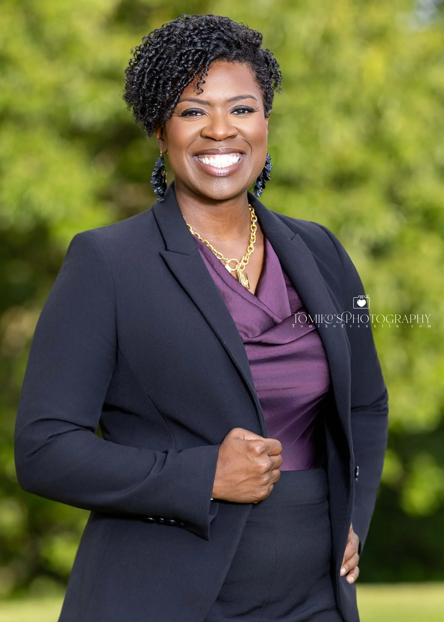 Environmental headshot of a woman outdoors, showcasing a natural setting with a professional and approachable demeanor.