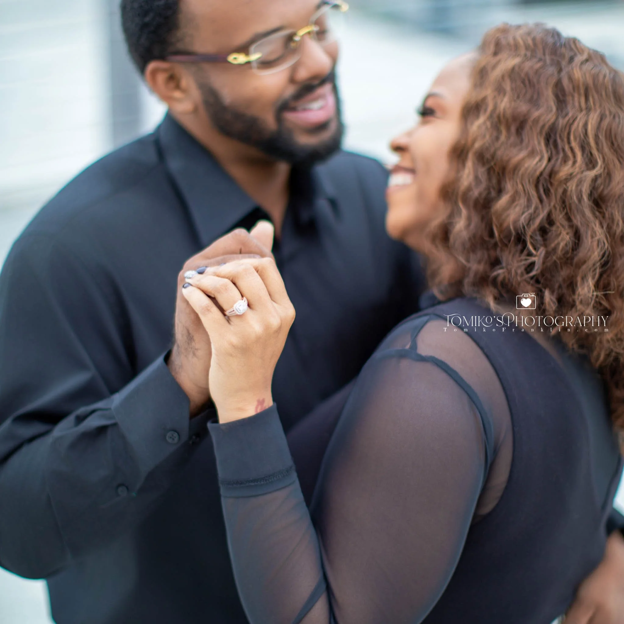 Couple posing on a Birmingham rooftop during their engagement session with luxury, warm sunset editing.