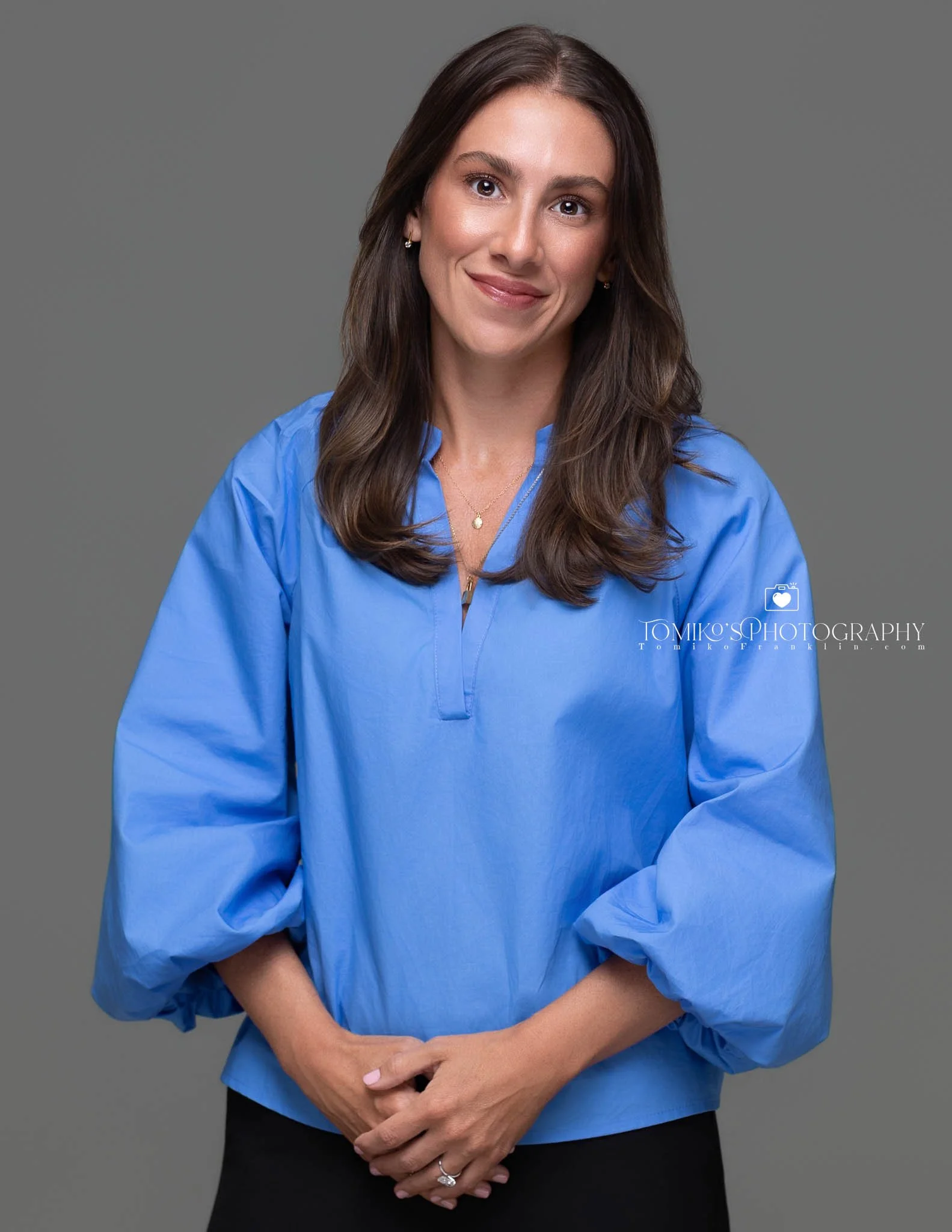 Environmental headshot of a woman outdoors, showcasing a natural setting with a professional and approachable demeanor.