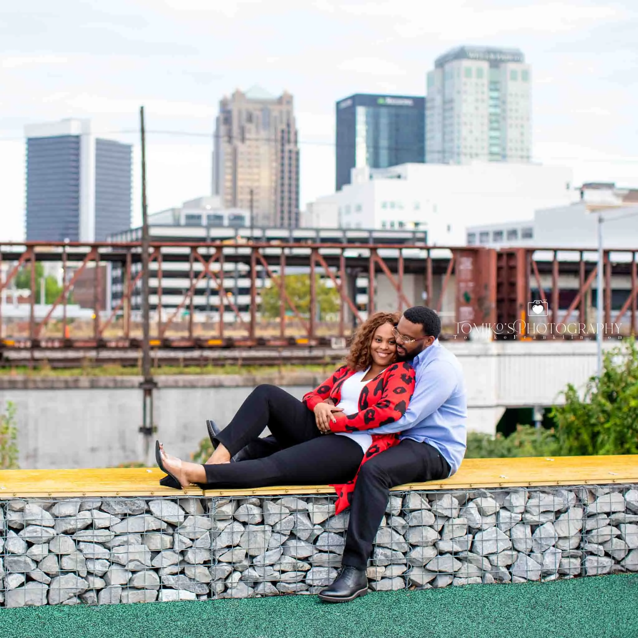 Romantic rooftop engagement session overlooking downtown Birmingham with warm golden hour lighting.